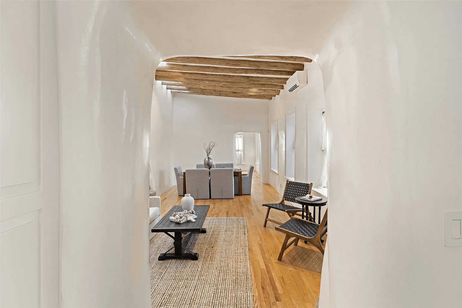 A living room with hardwood floors , a coffee table and chairs.