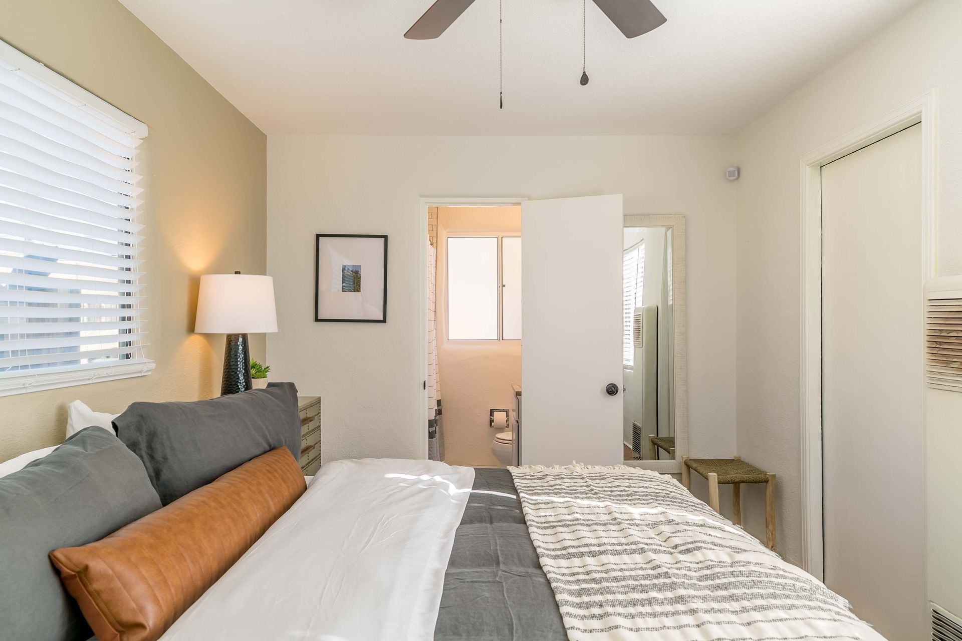 A bedroom with a large bed and a ceiling fan