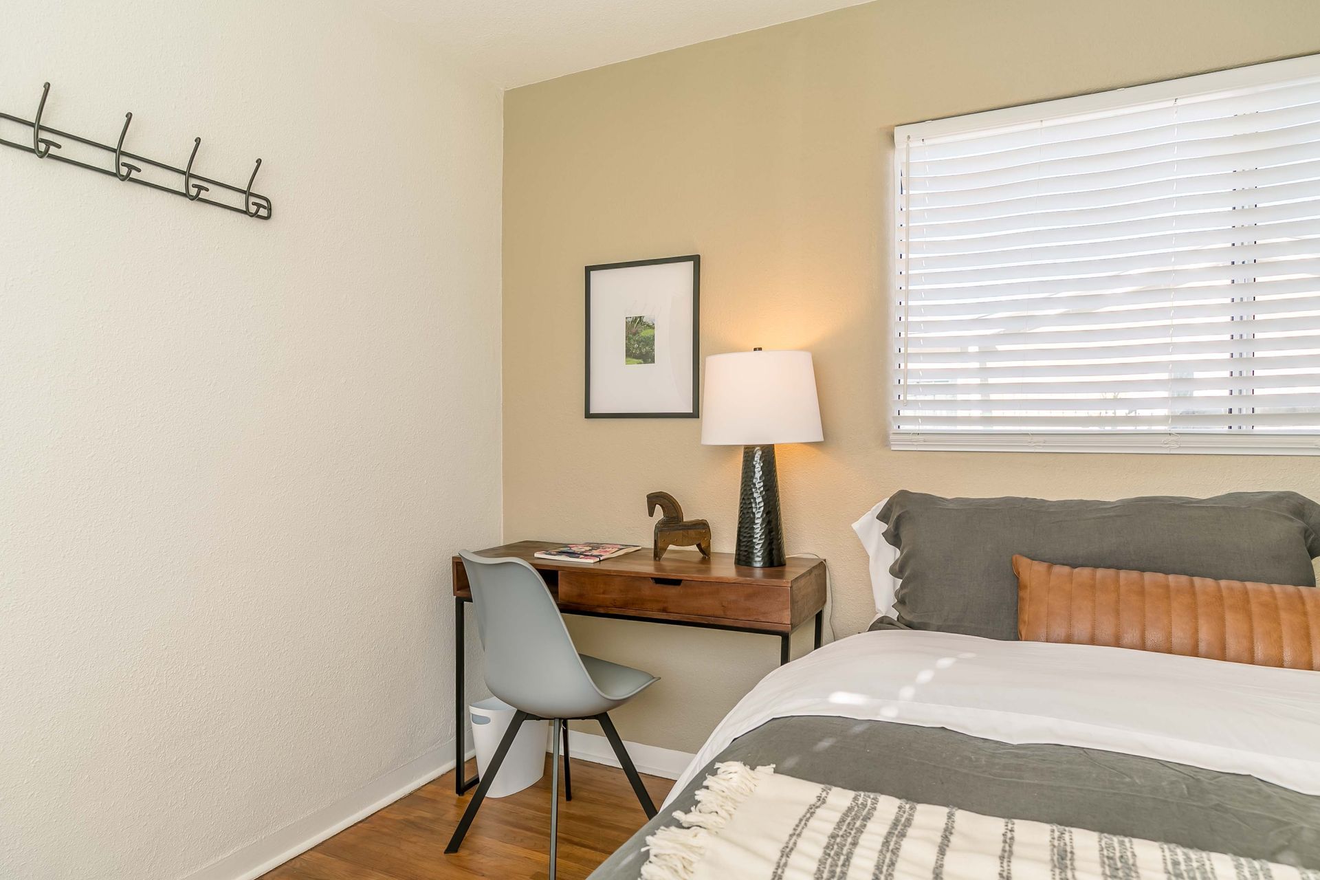 A bedroom with a bed , desk , chair and lamp