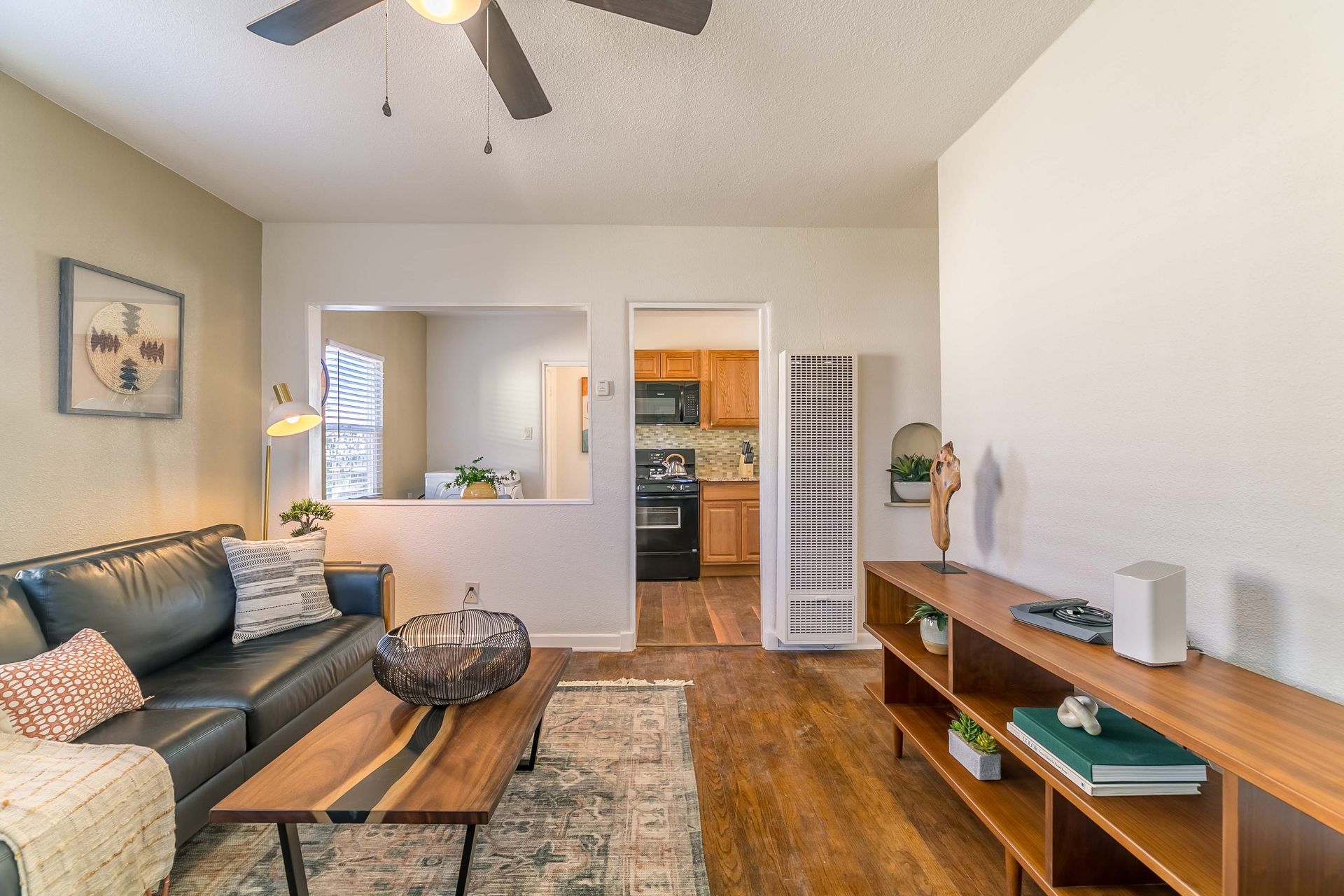 A living room with a couch , coffee table , and ceiling fan.