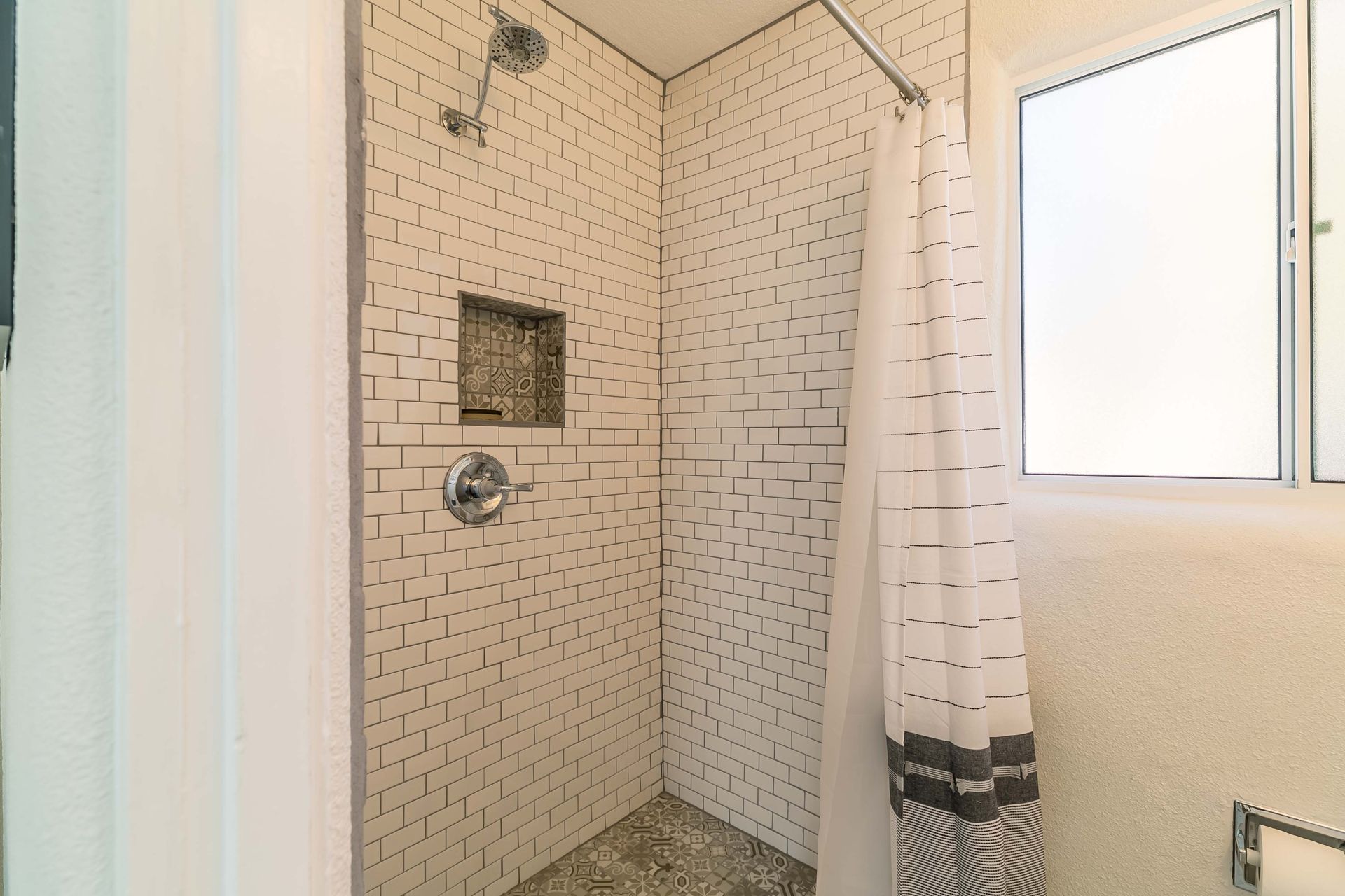 A bathroom with a walk in shower and a window