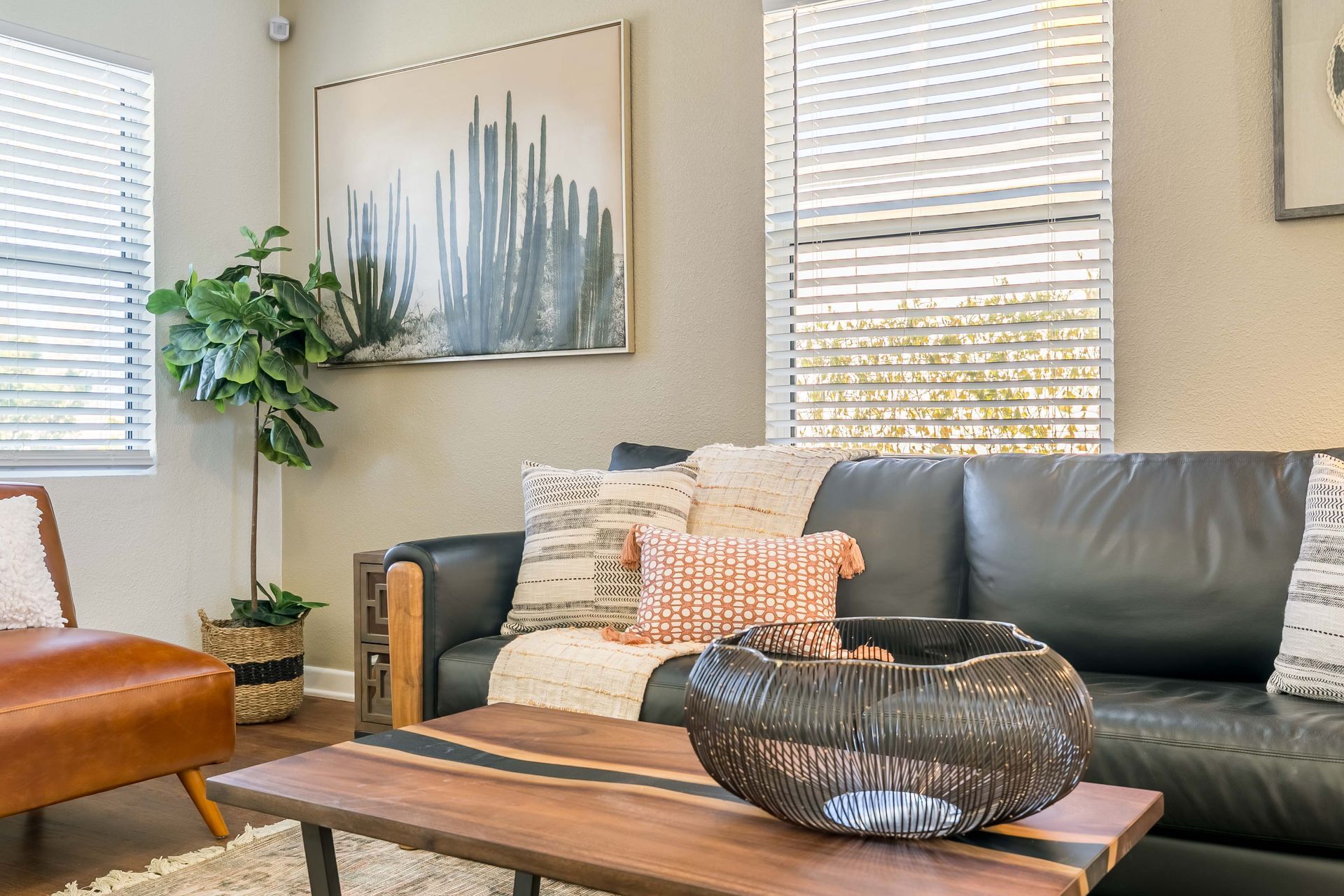 A living room with a black couch and a wooden coffee table.