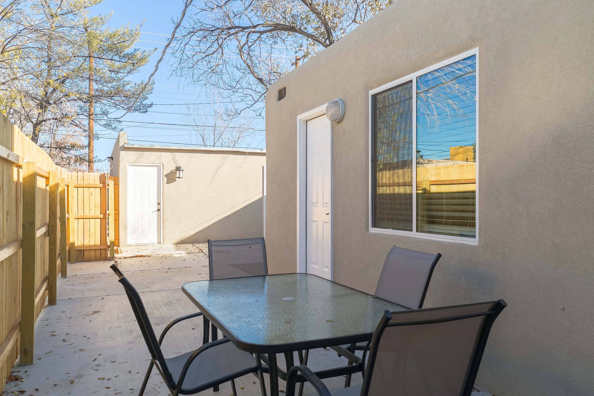 There is a table and chairs in the backyard of a house.