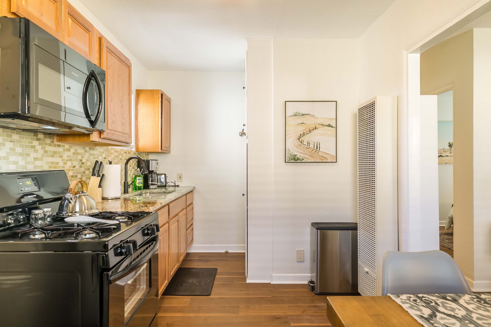 A kitchen with a stove , microwave , refrigerator and sink.