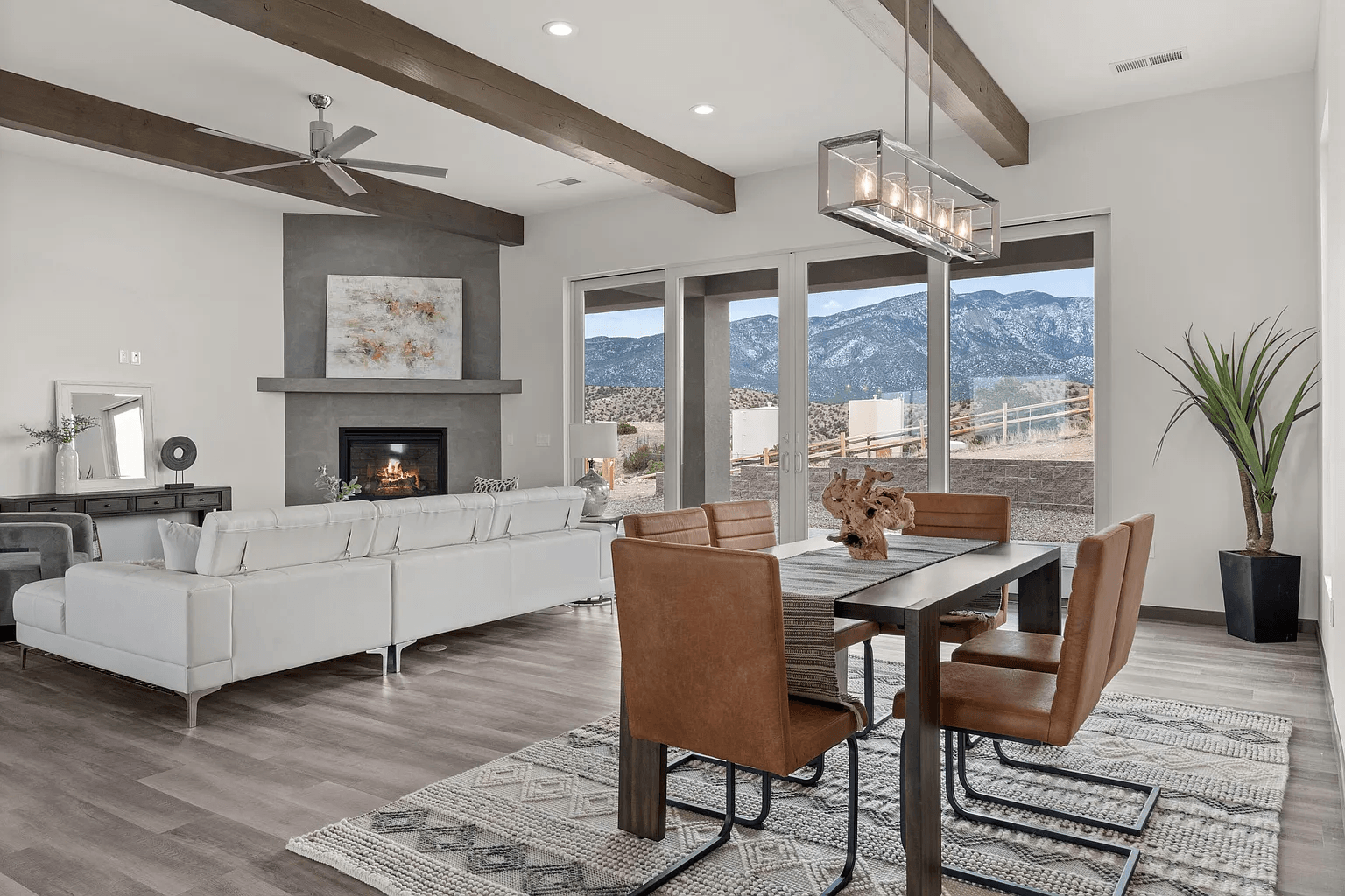 A living room with a dining table and chairs and a fireplace.