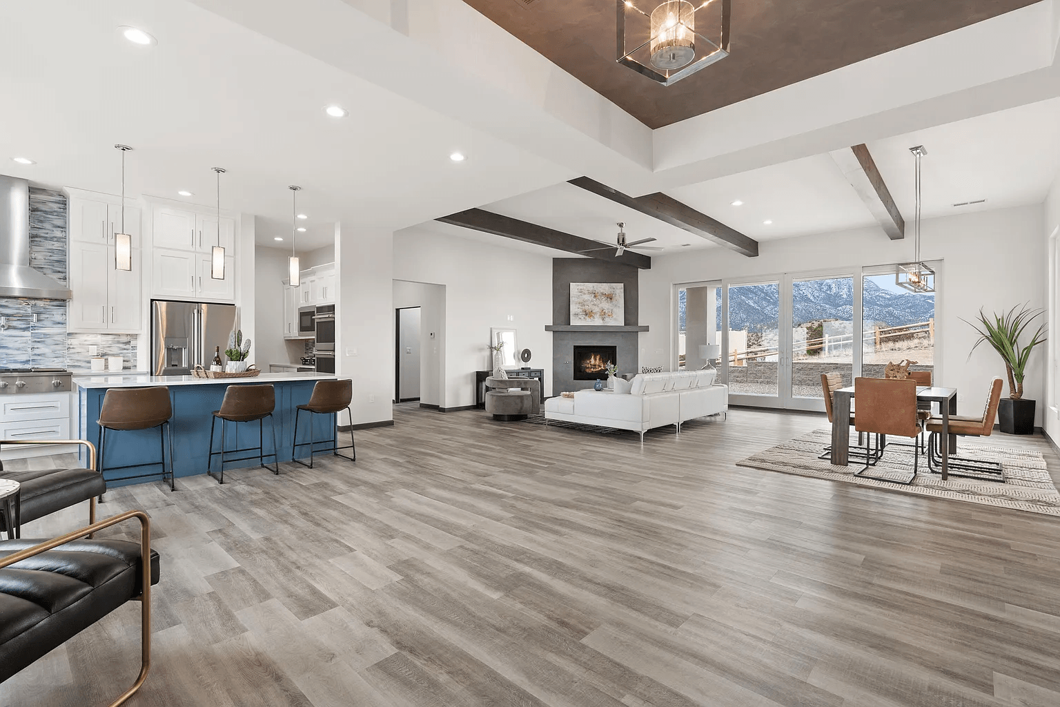 A living room , dining room , and kitchen in a house with hardwood floors.