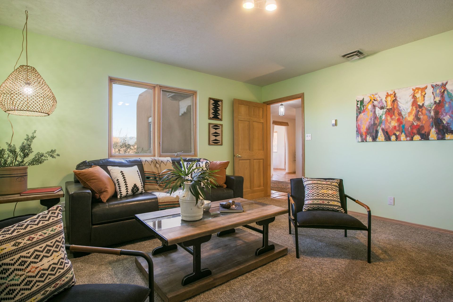 A living room with a couch , chairs , and a coffee table.
