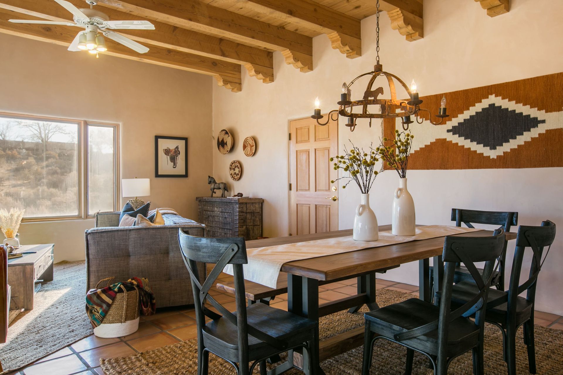 A living room with a dining table and chairs and a ceiling fan.