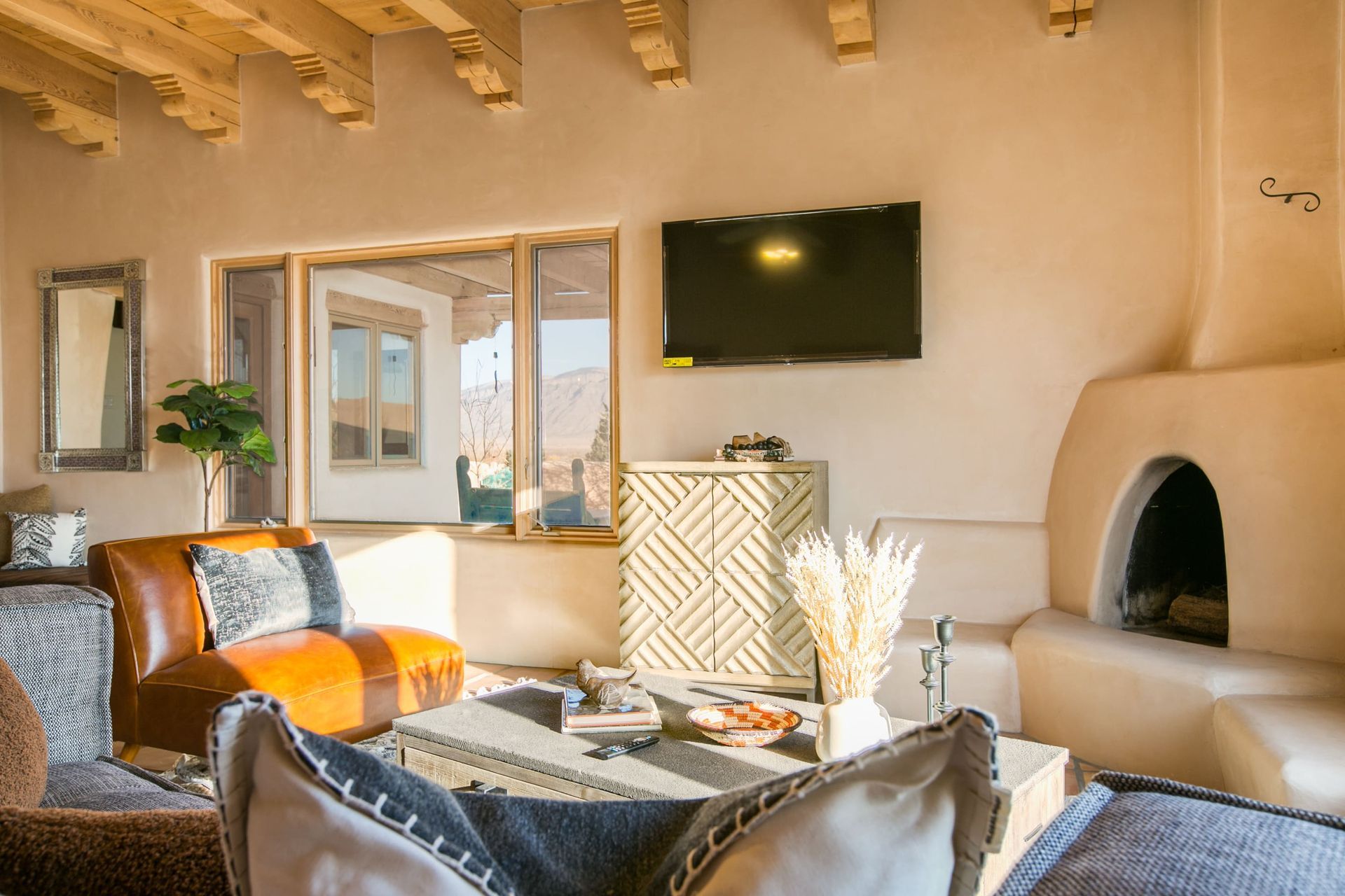 A living room with a couch , chair , fireplace and television.