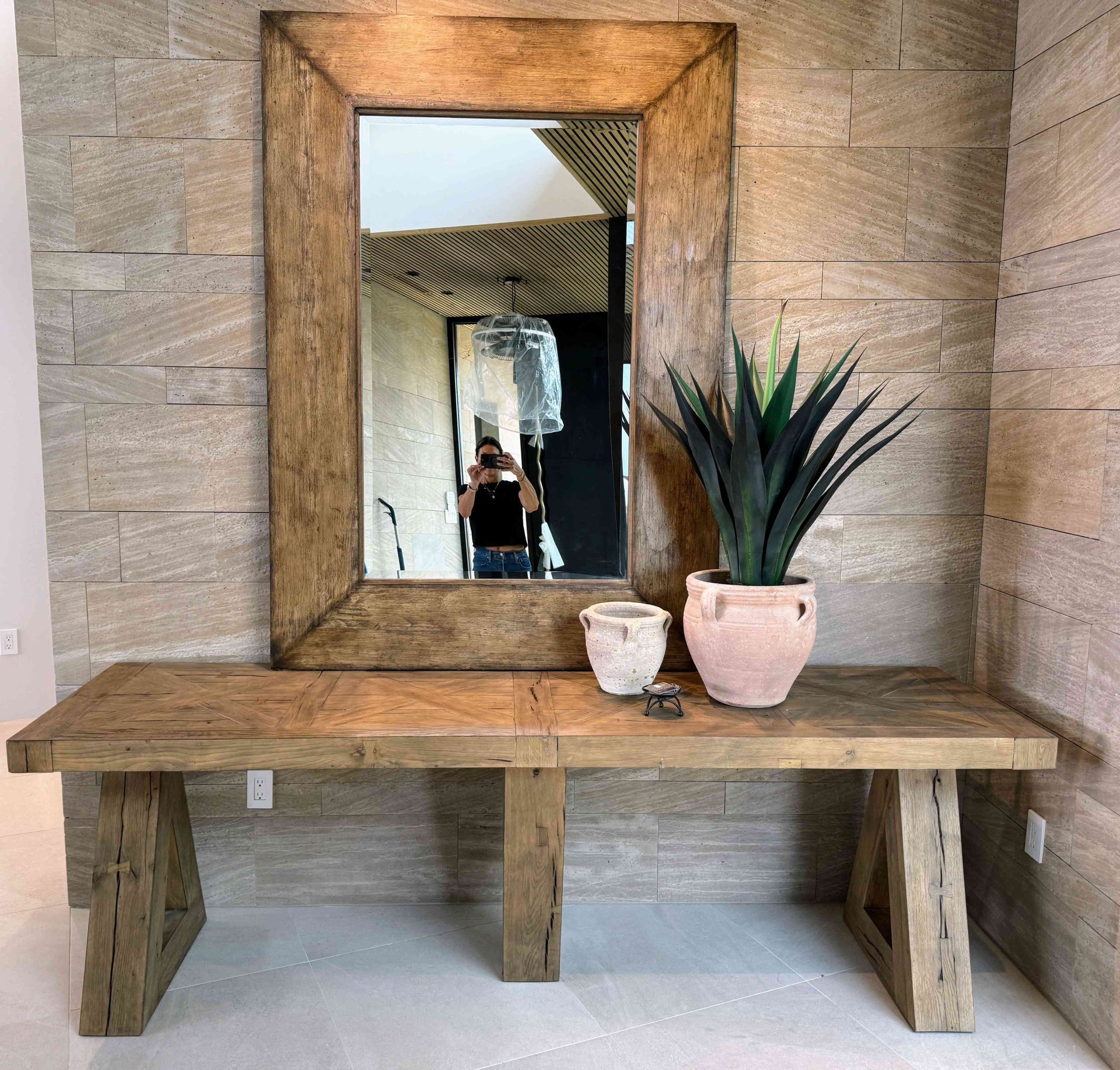 A wooden table with a mirror and potted plants on it