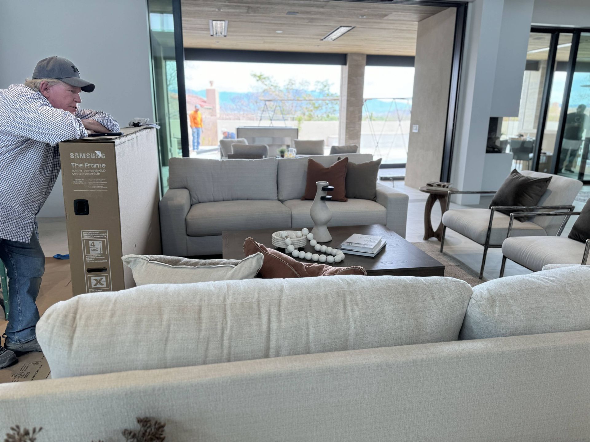 A man is standing next to a couch in a living room.