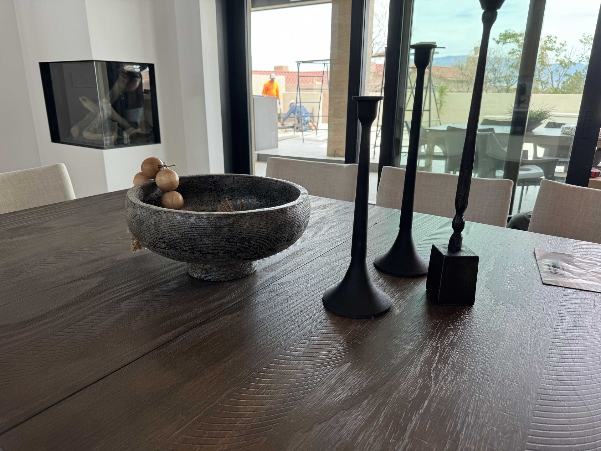 A wooden table with a bowl and candles on it