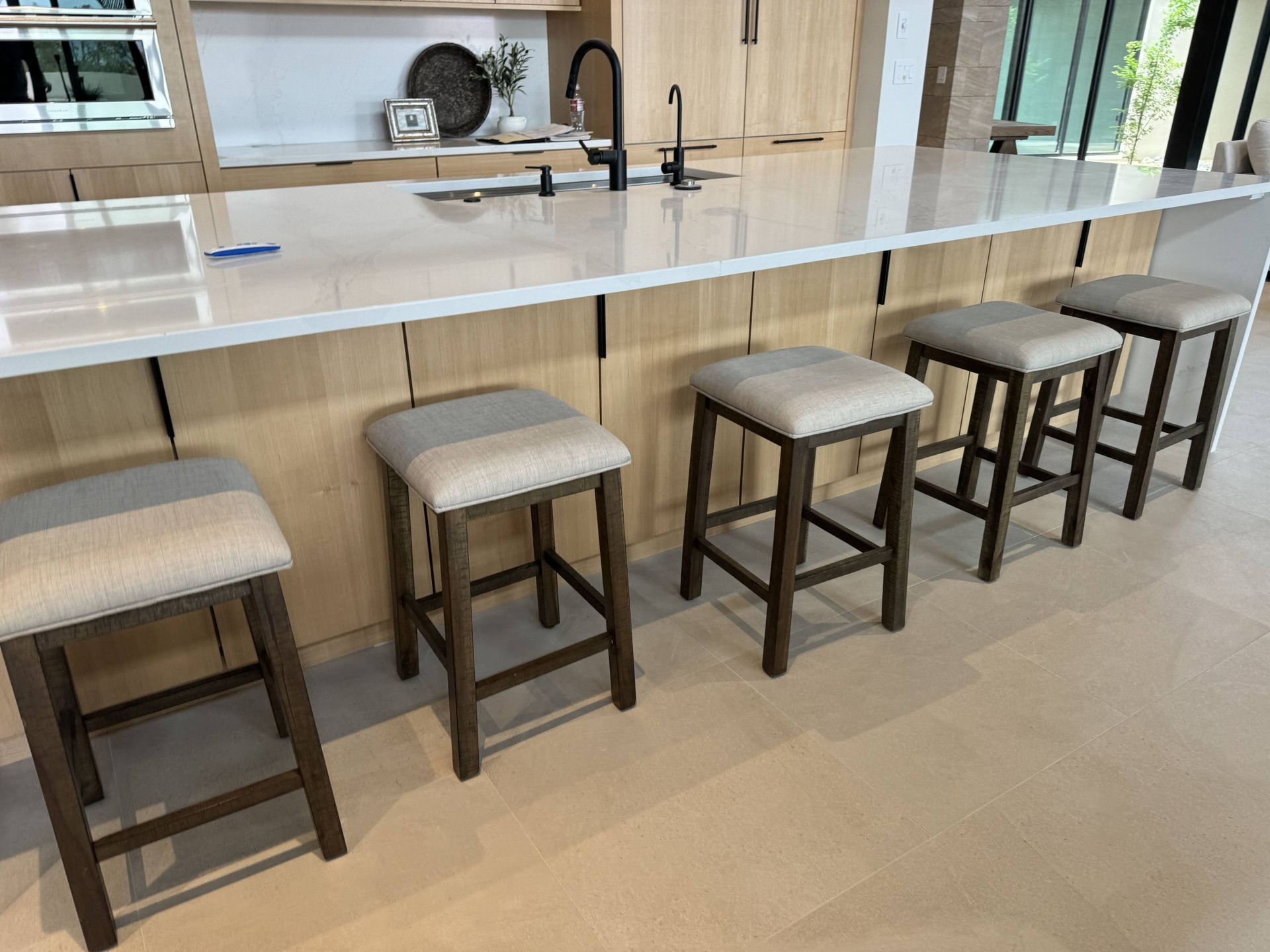 A kitchen with a long counter and stools on it.