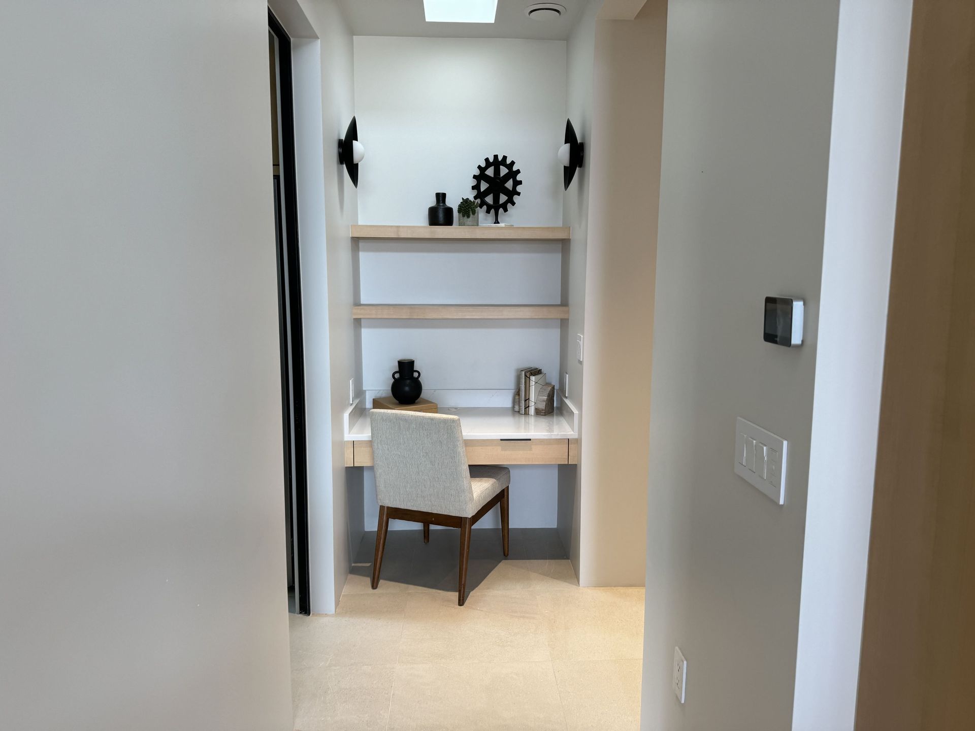 A hallway with a desk and chair in the middle of it.