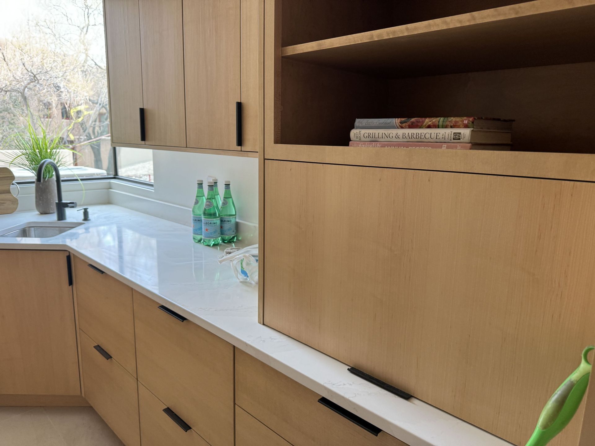 A kitchen with wooden cabinets and white counter tops