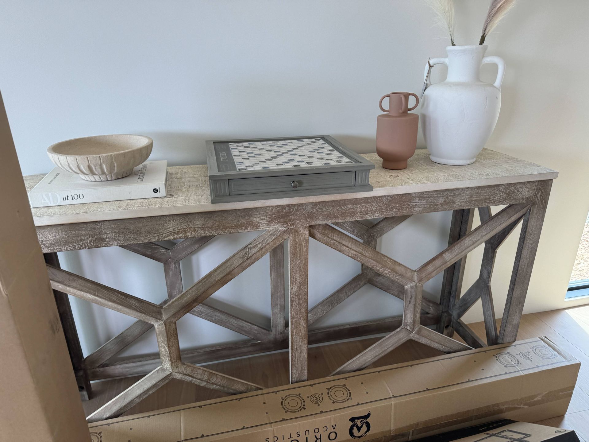 A wooden table with a bowl and vases on it