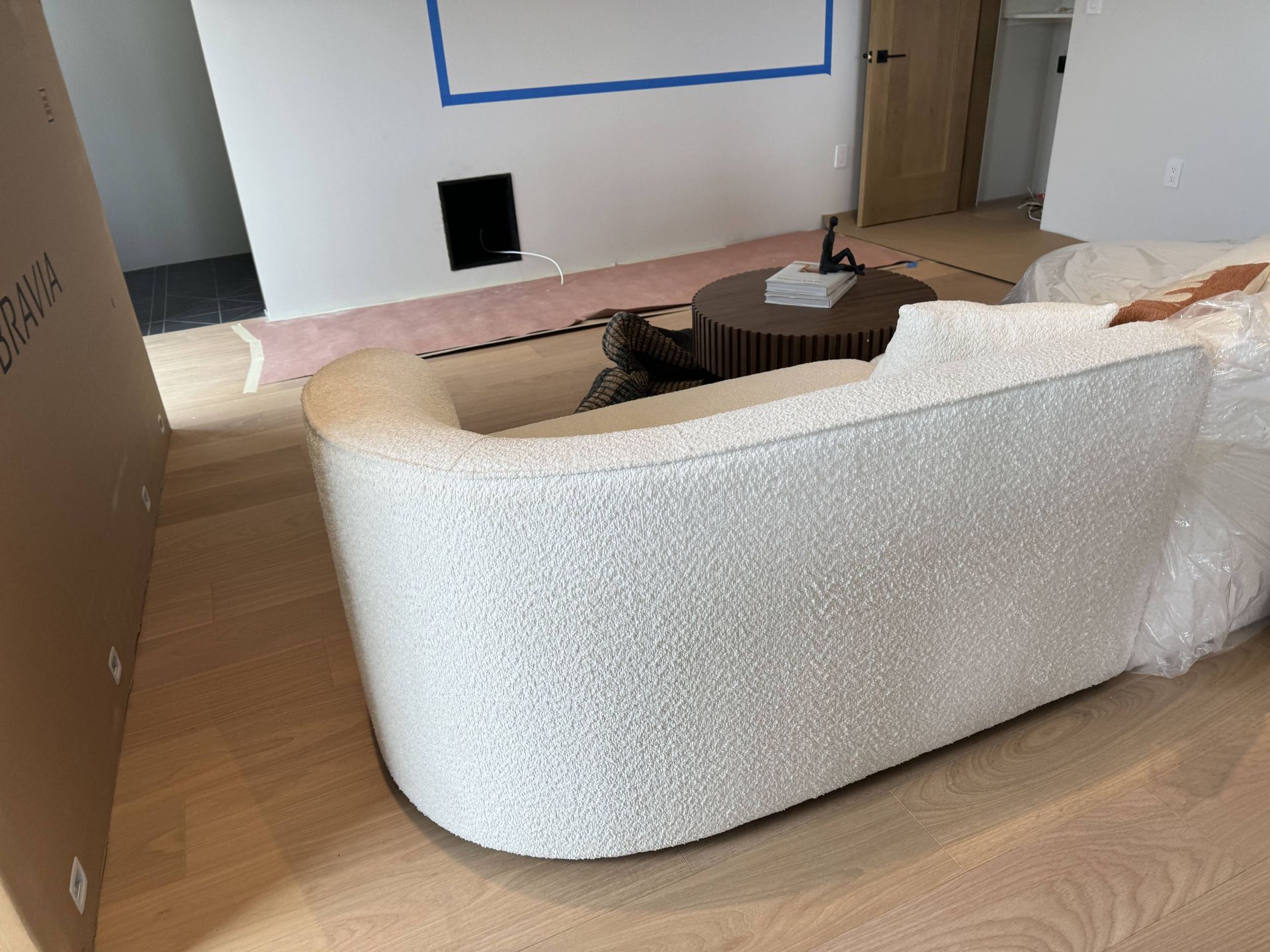 A living room with a white couch and a brown coffee table.