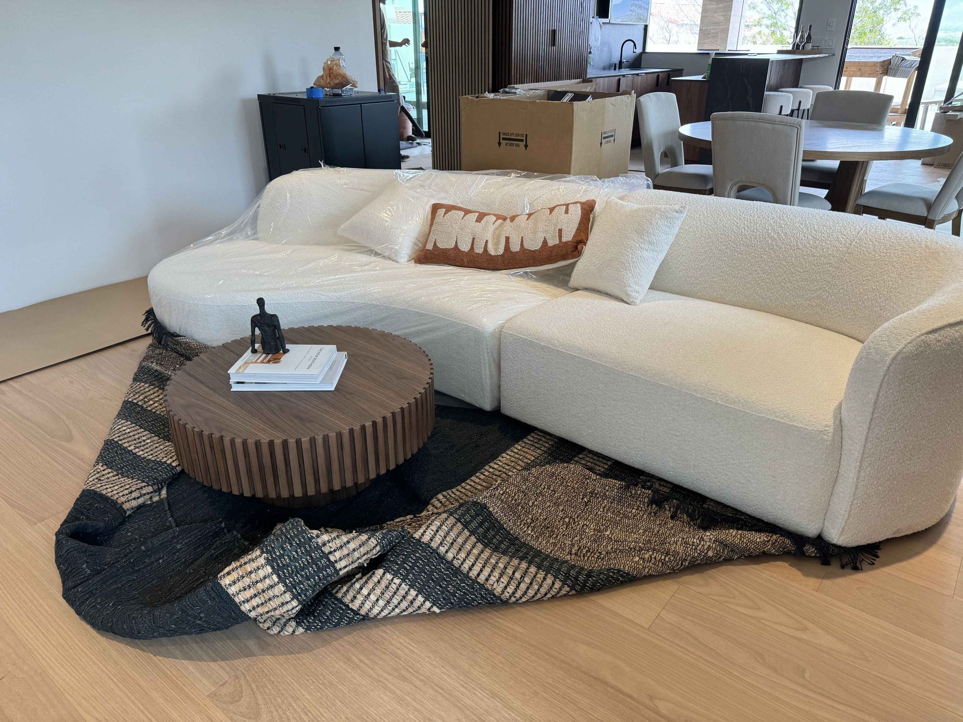 A white couch is sitting on top of a rug in a living room.