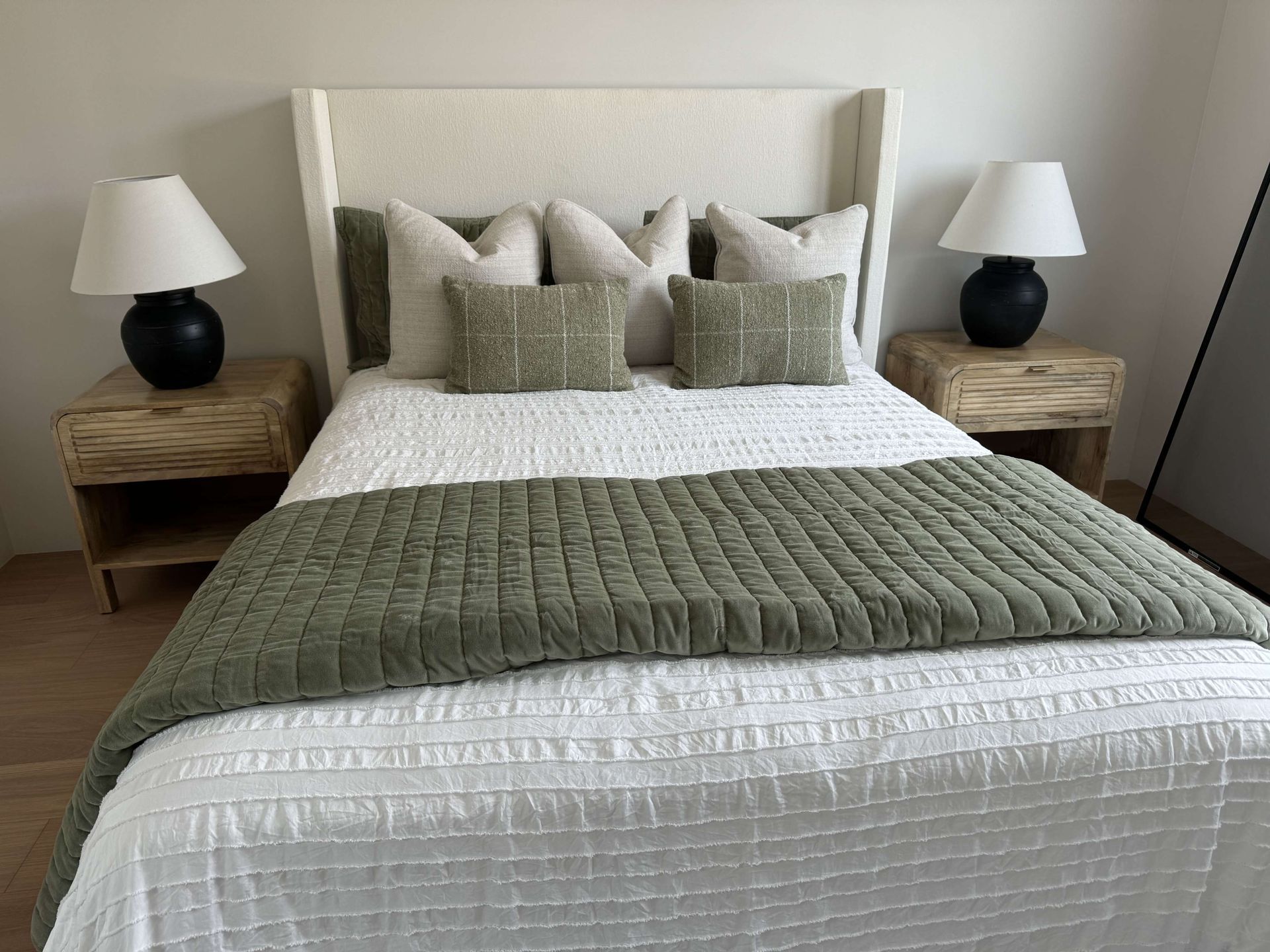 A bedroom with a bed , two nightstands and two lamps.