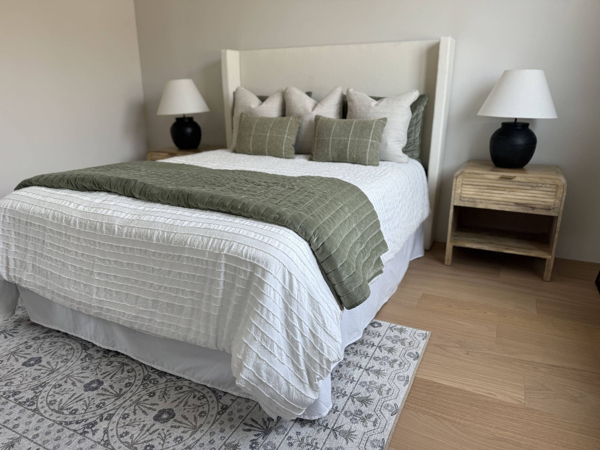 A bedroom with a bed , nightstand and lamps