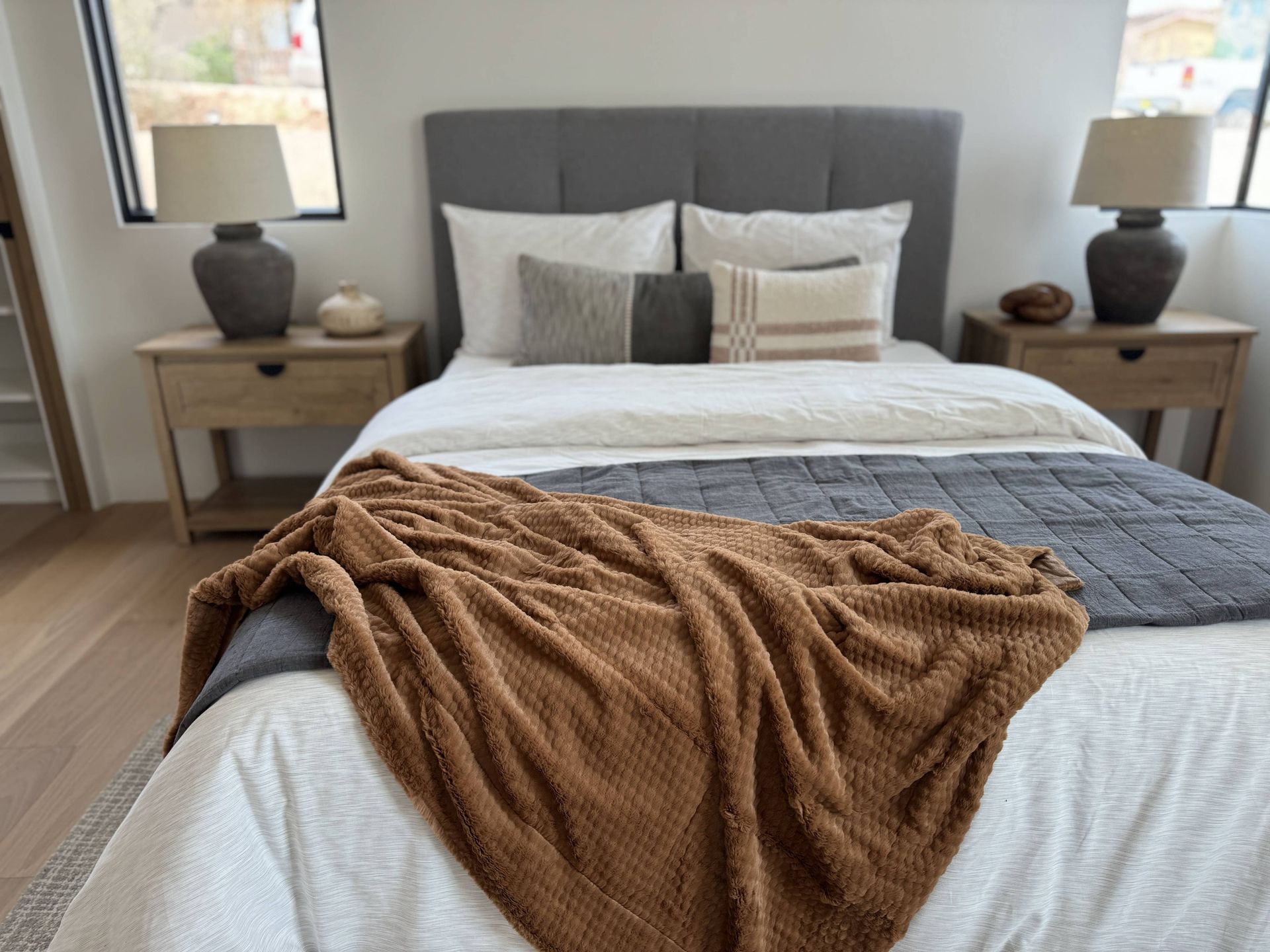 A bed with a brown blanket on it in a bedroom