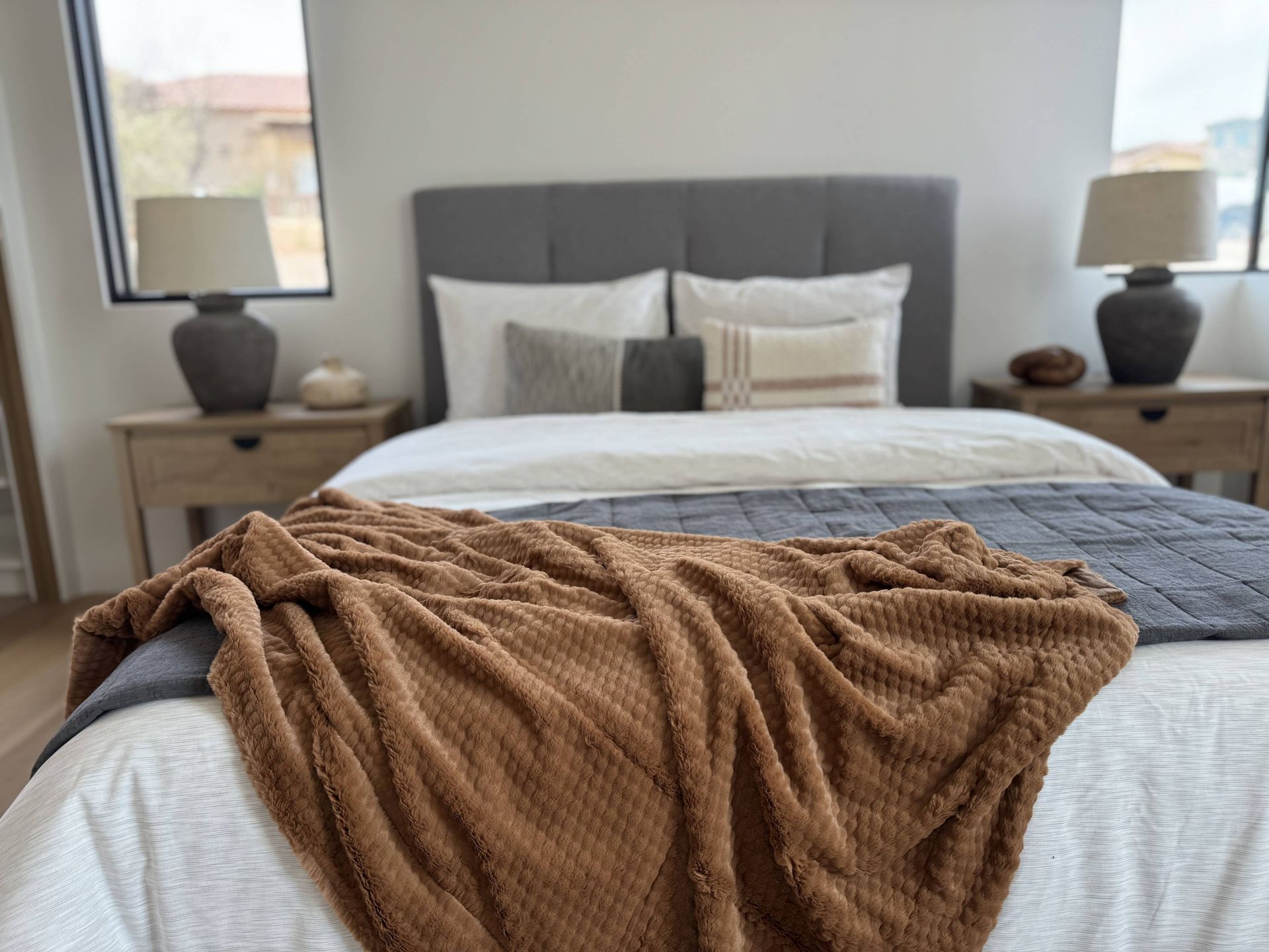 A bed with a brown blanket on it in a bedroom