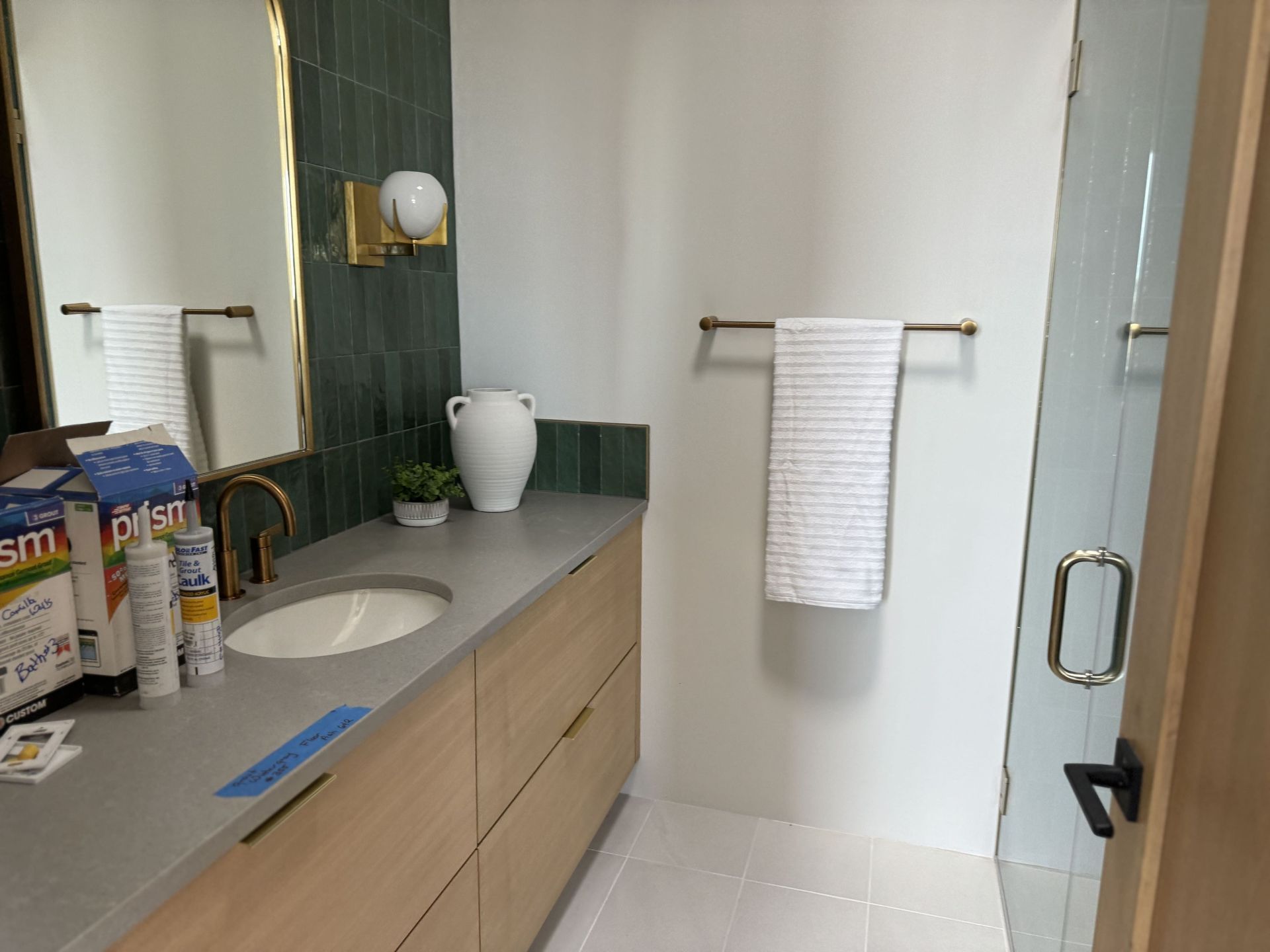 A bathroom with a sink , mirror , and towel rack.