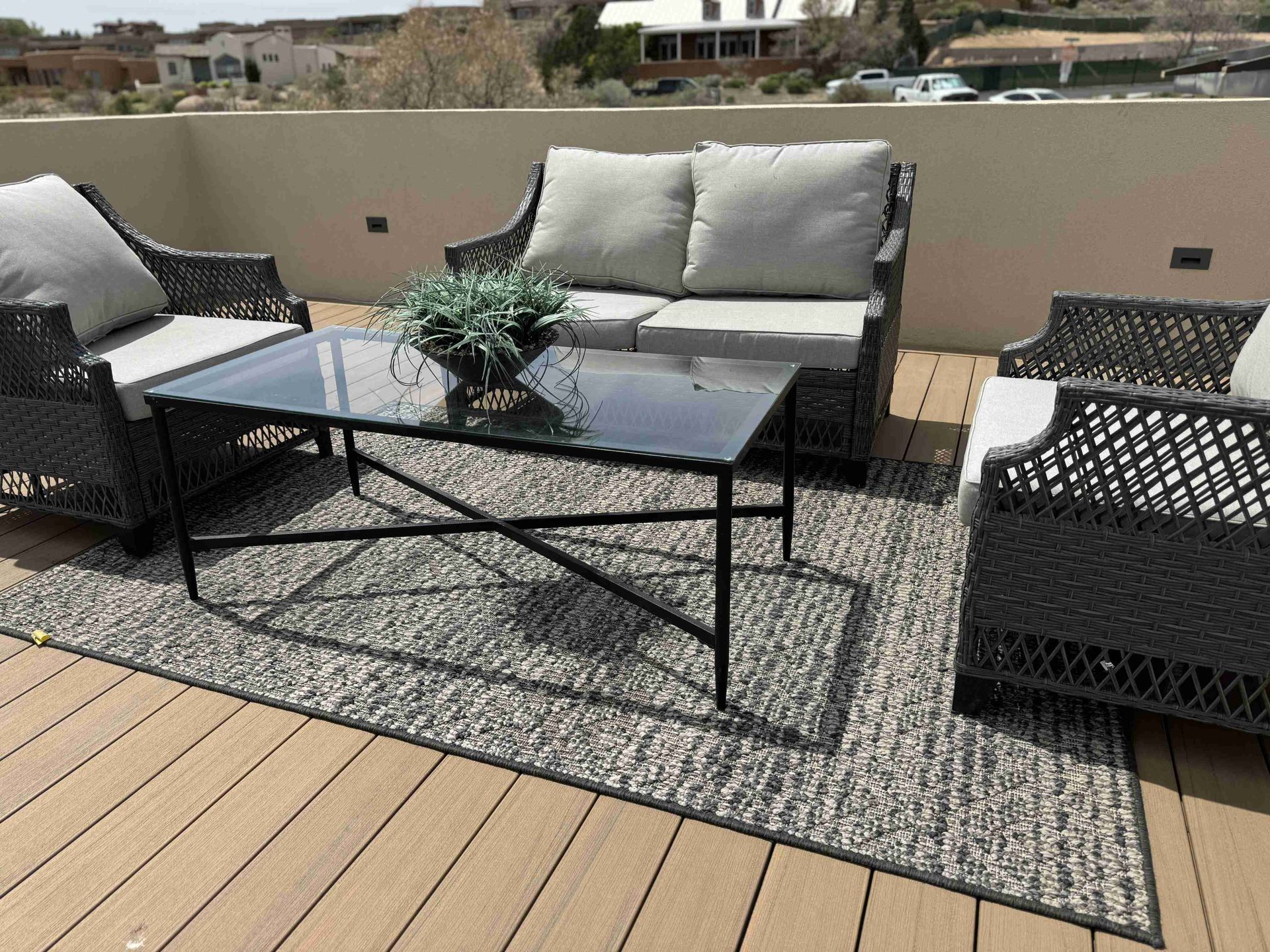 A deck with a couch , chairs , and a coffee table