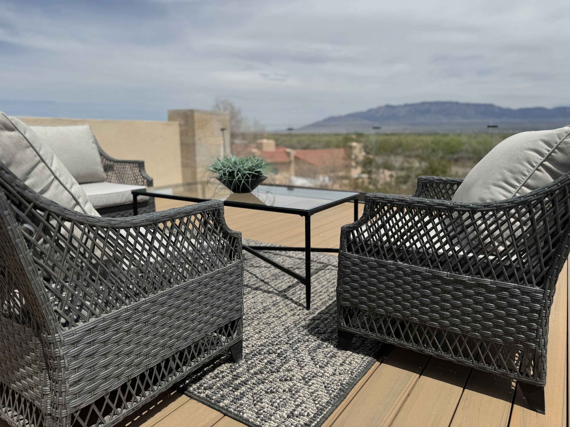 There are two chairs and a table on the deck.