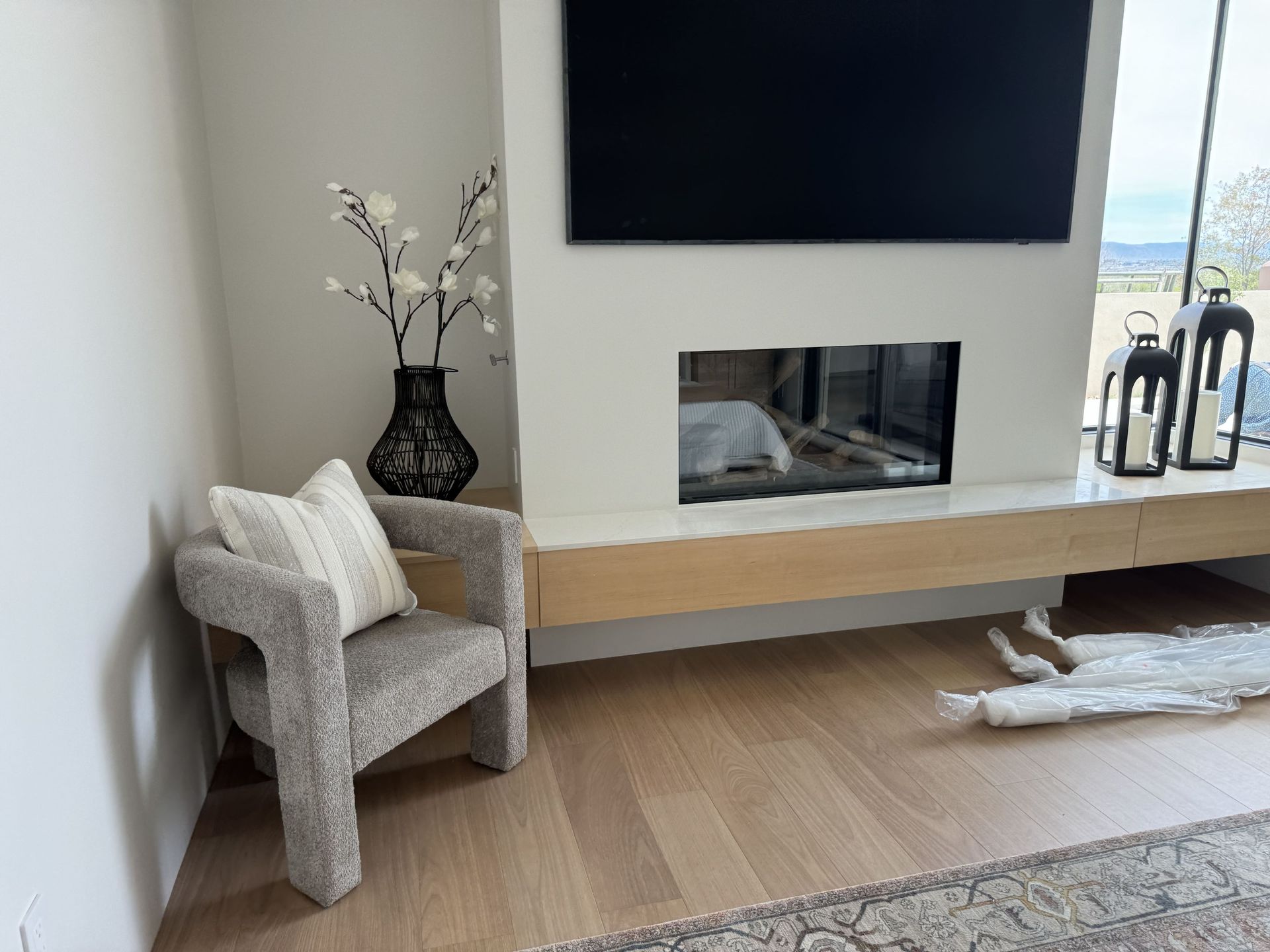 A living room with a chair , television and fireplace.