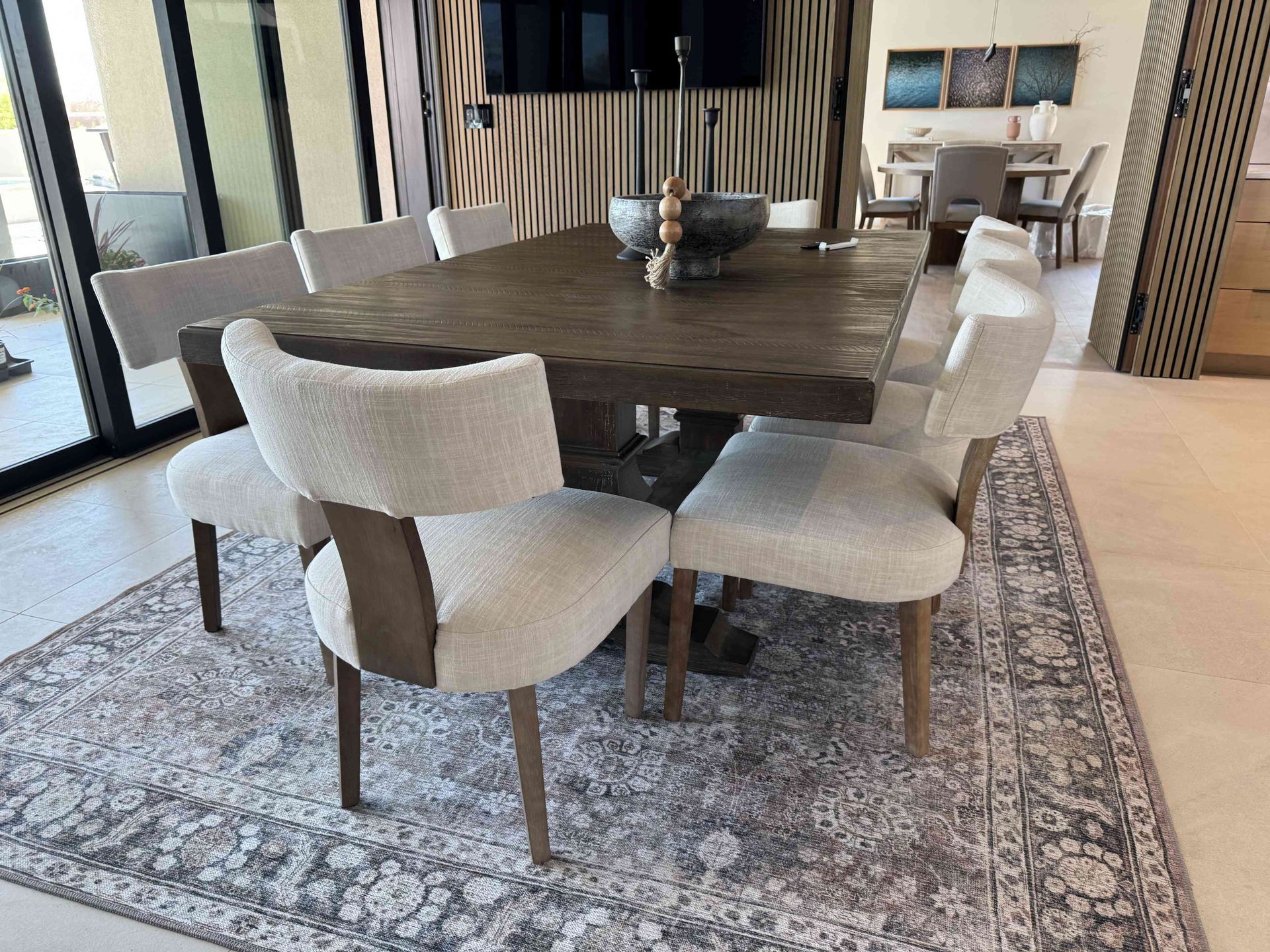 A dining room table and chairs are sitting on a rug.
