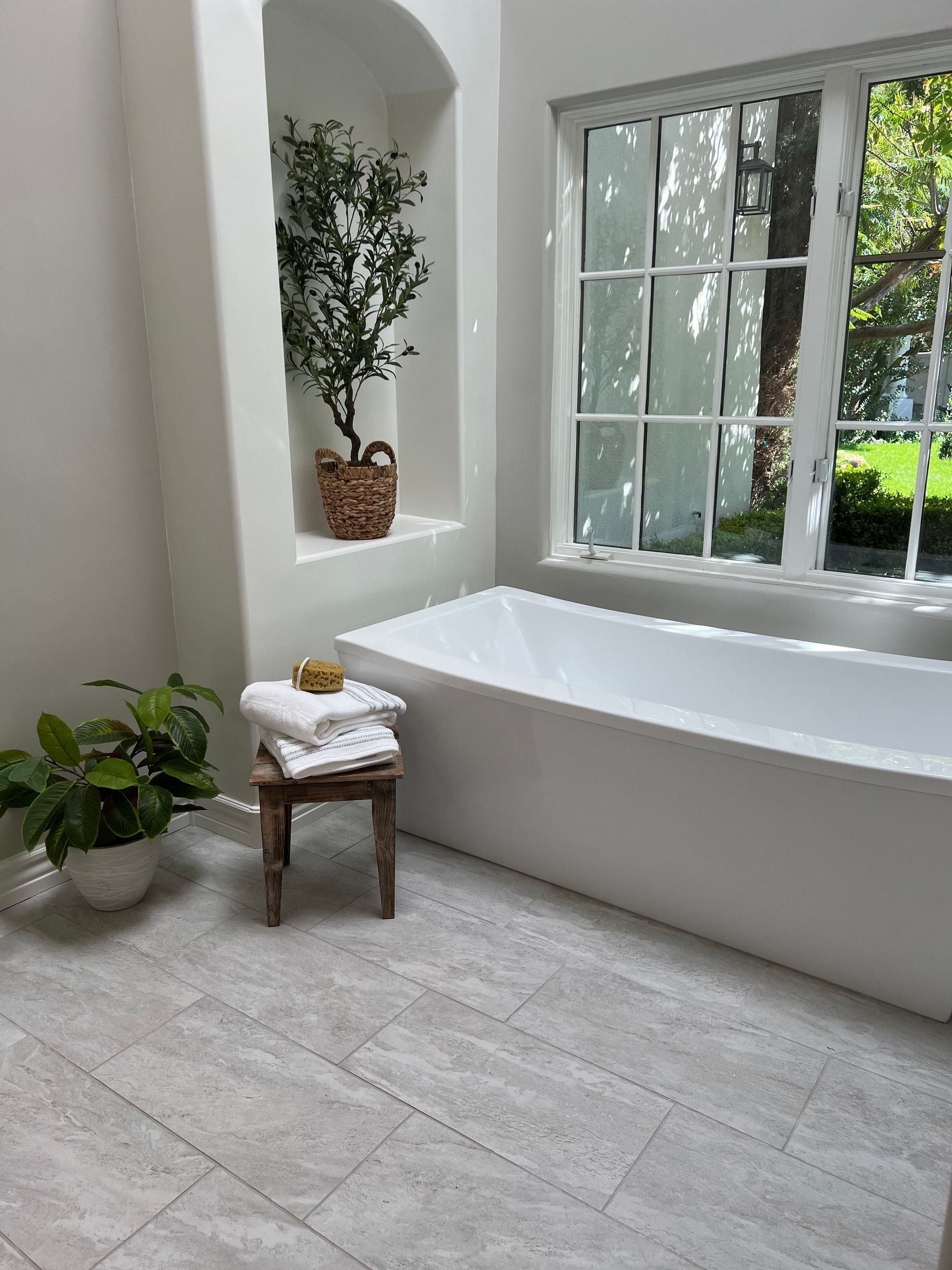 A bathroom with a bathtub and a window