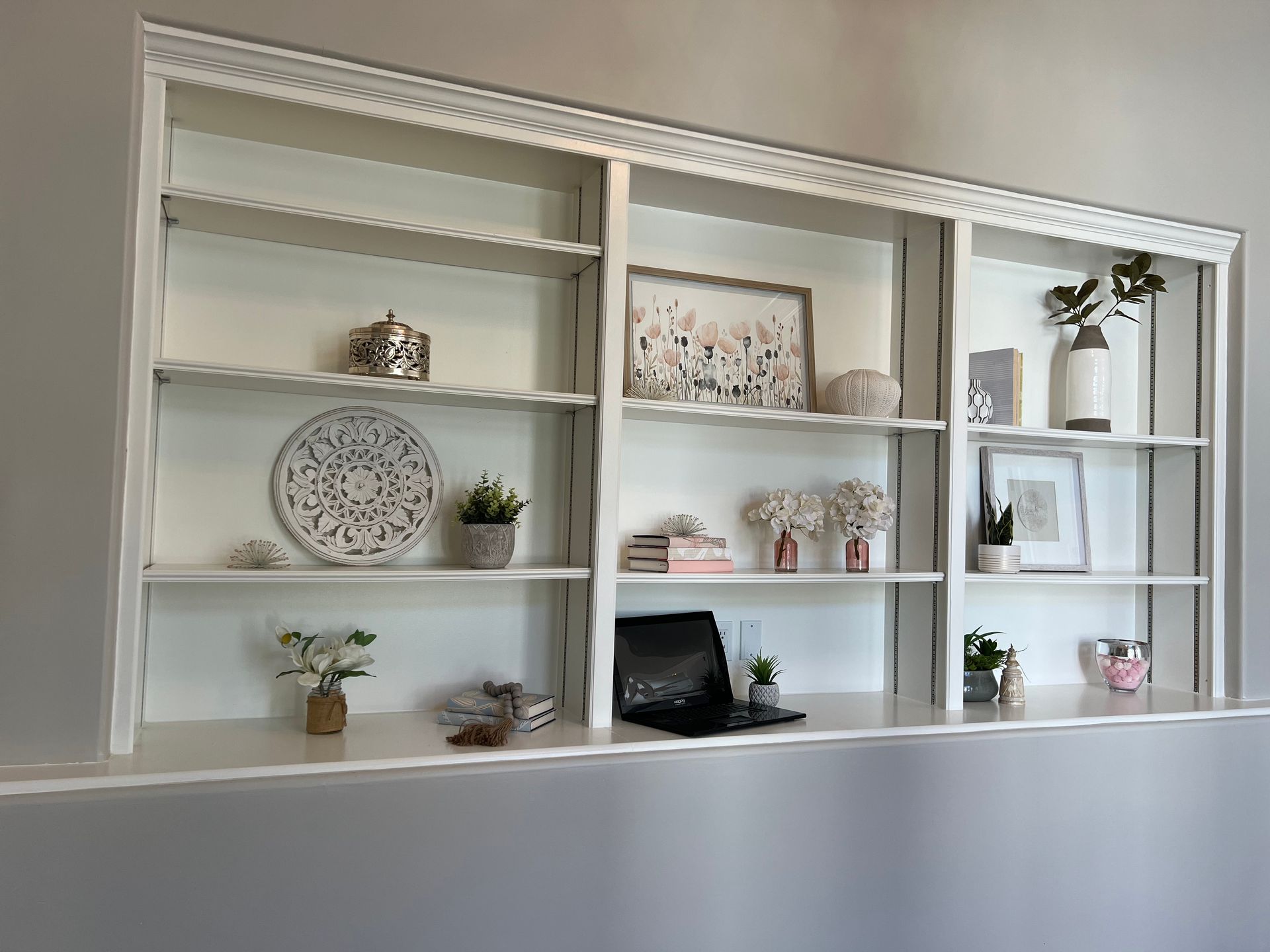 There is a desk in the middle of the bookshelf.