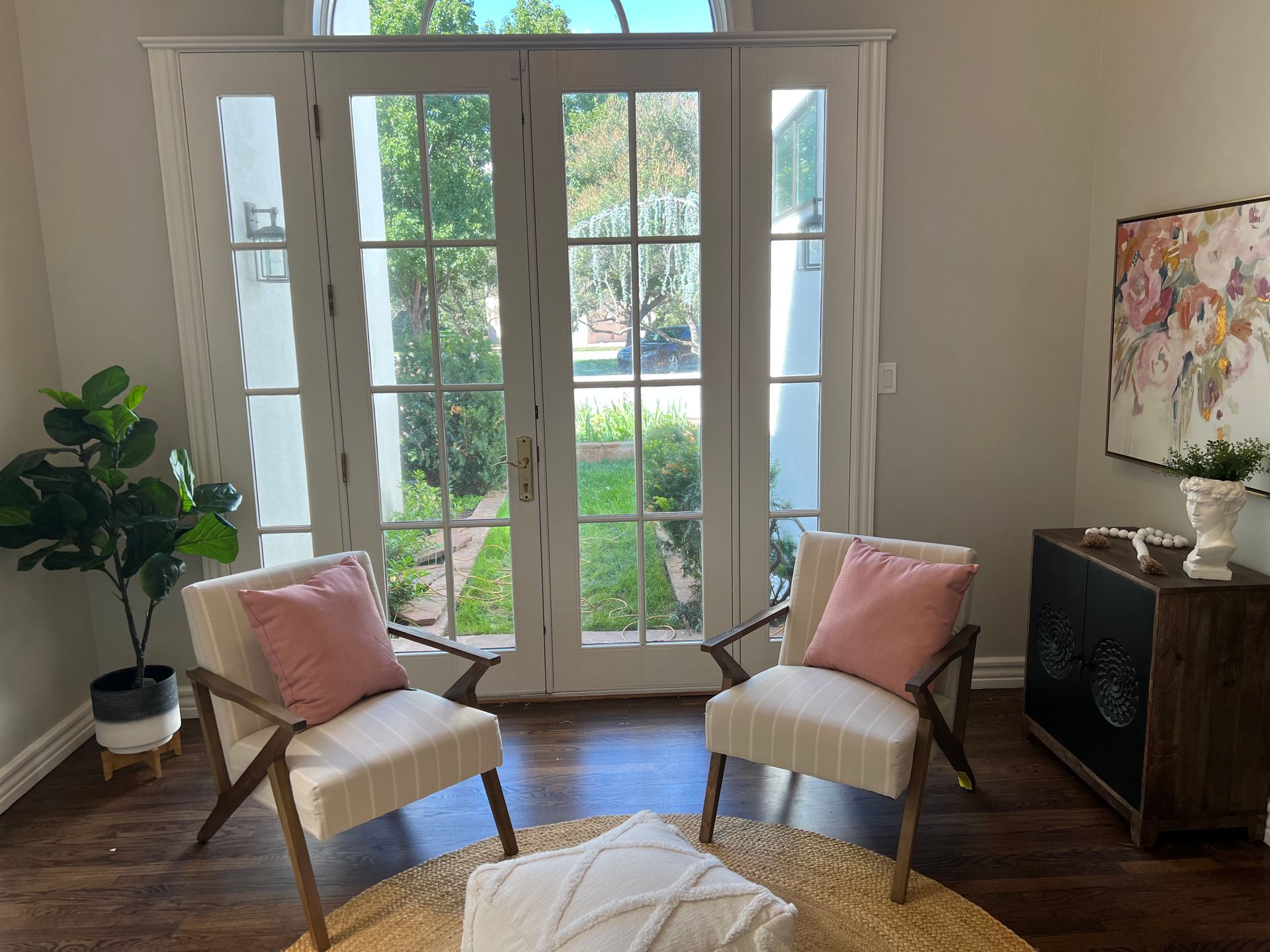 A living room with two chairs and a painting on the wall.