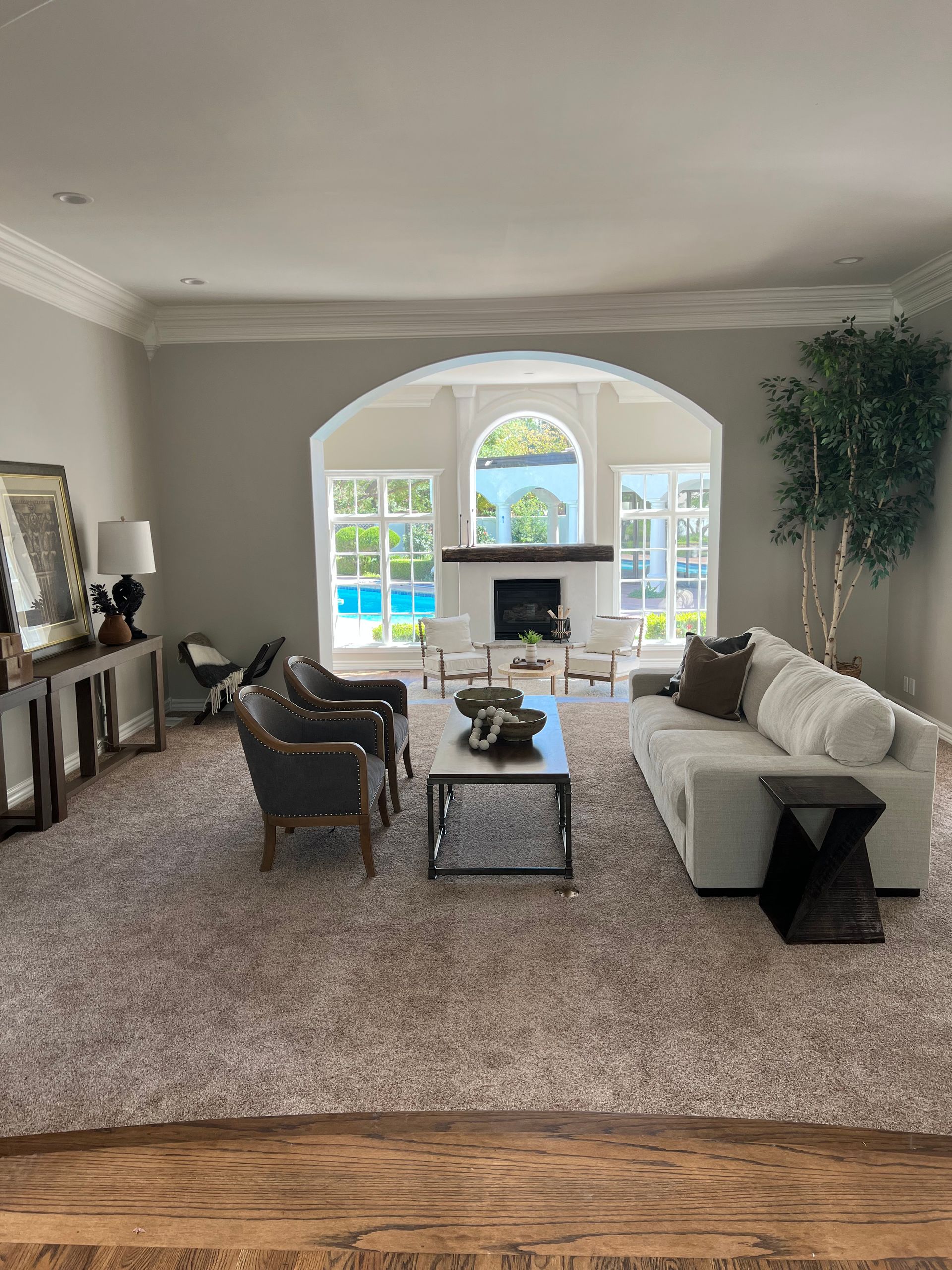 A living room with a couch , chairs , coffee table and fireplace.