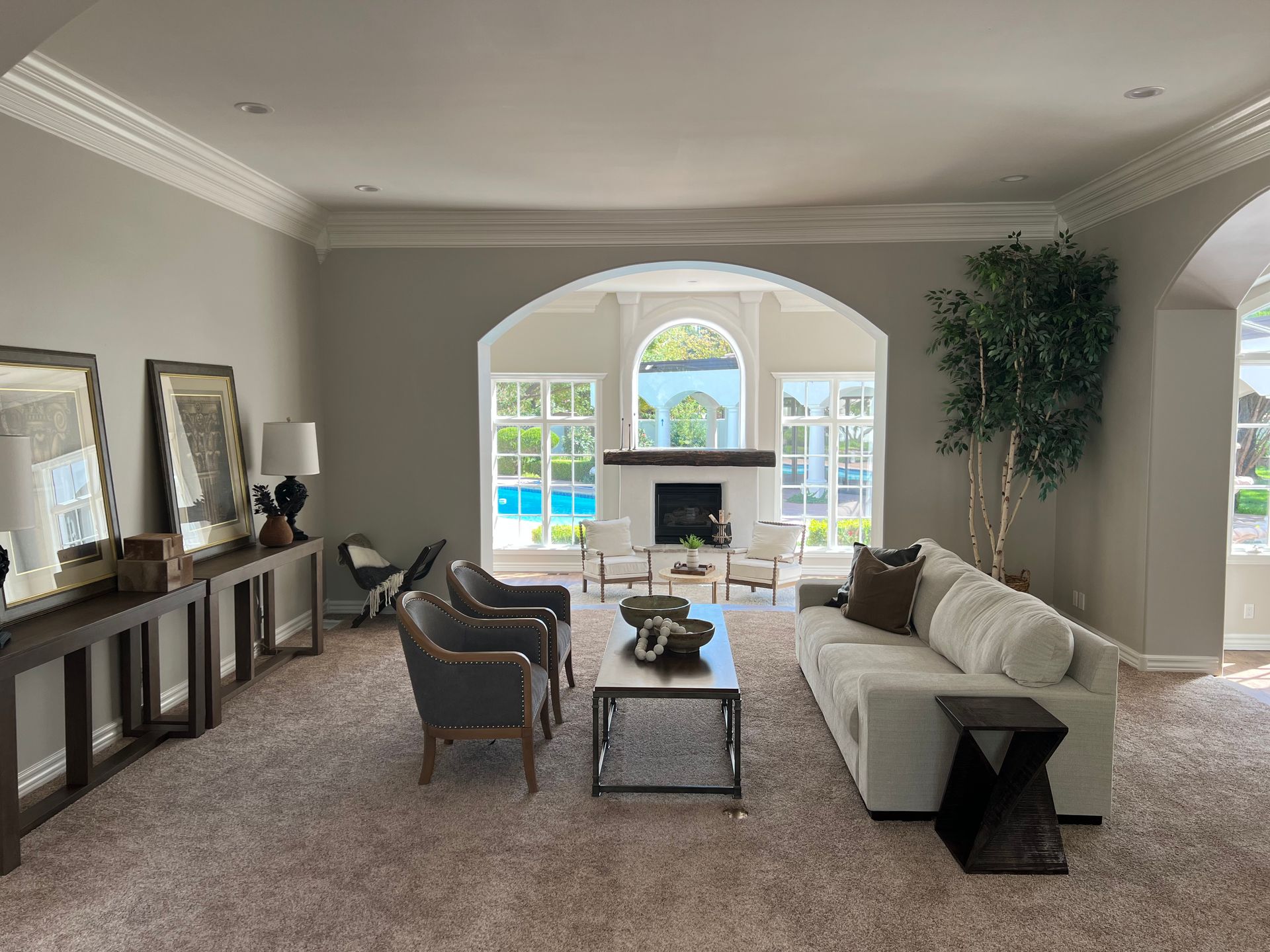 A living room with a couch , chairs , coffee table and fireplace.