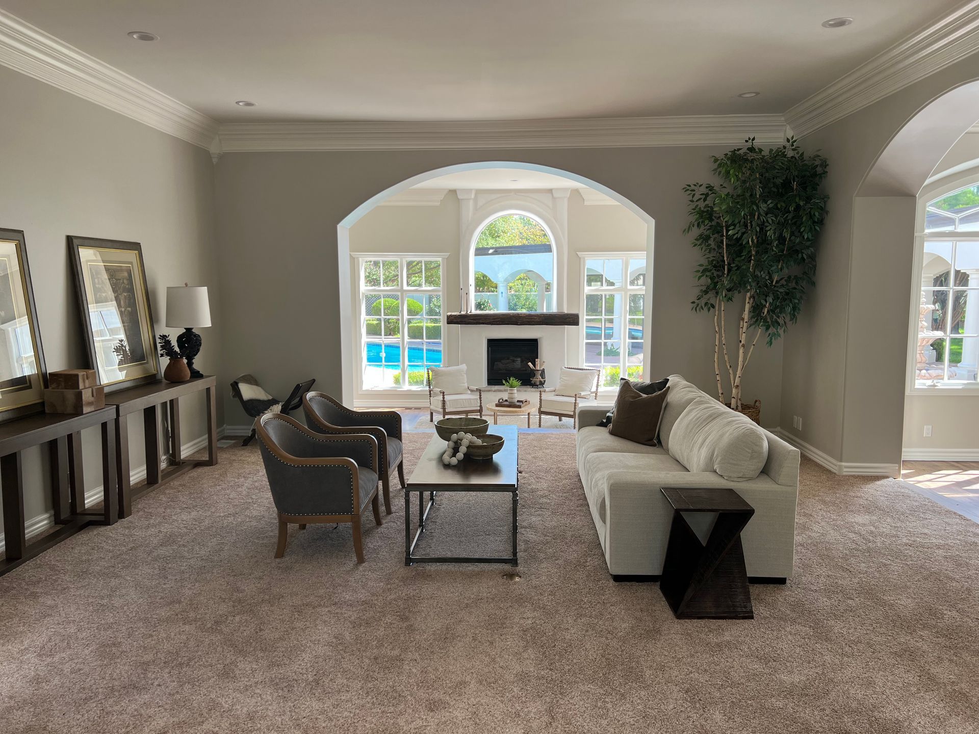 A living room with a couch , chairs , coffee table and fireplace.