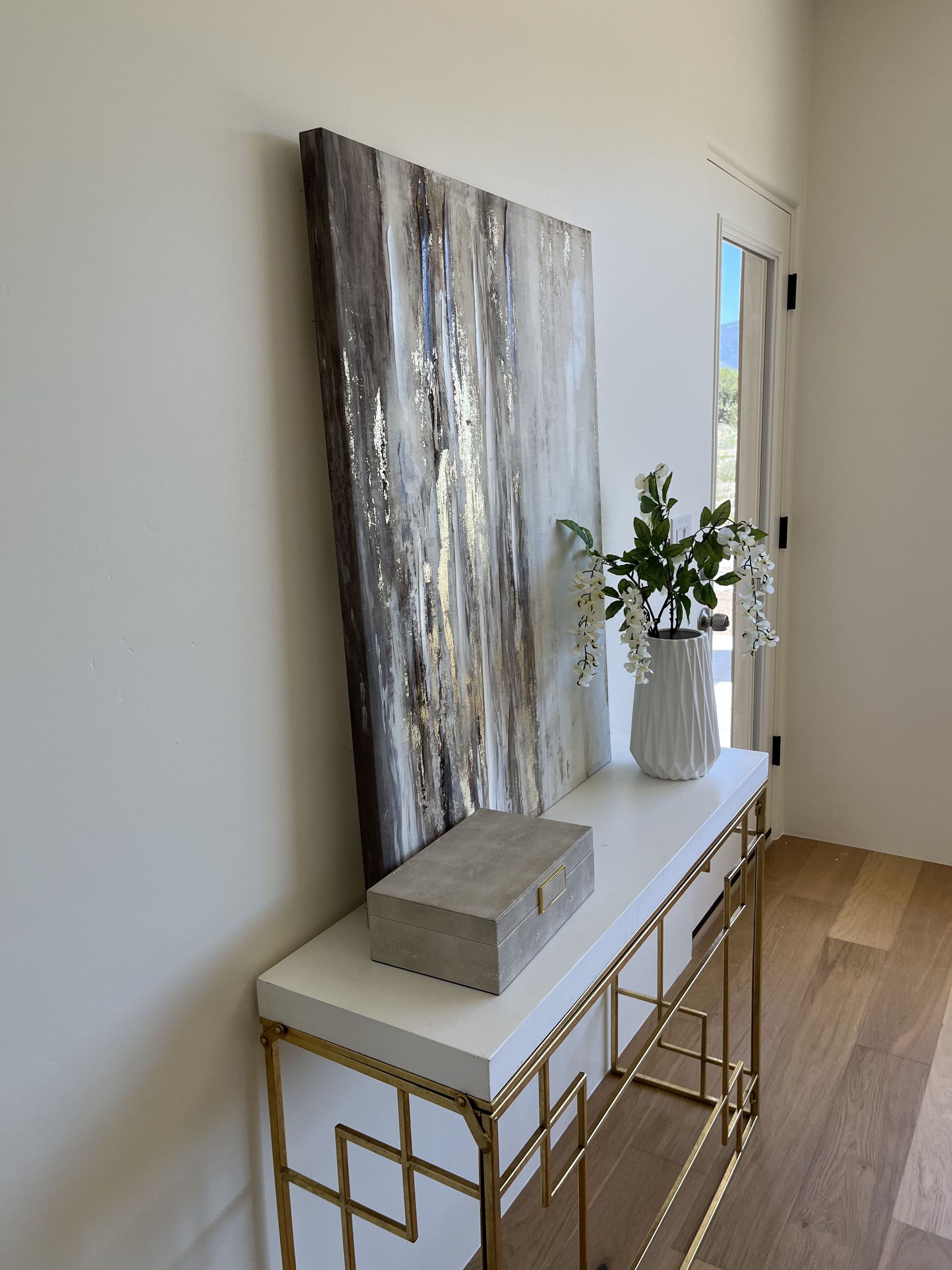 A hallway with a table and a painting on the wall