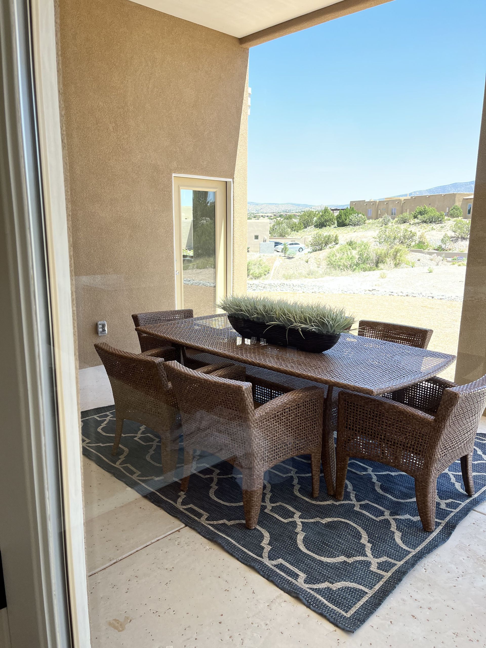 A patio with a table and chairs and a rug