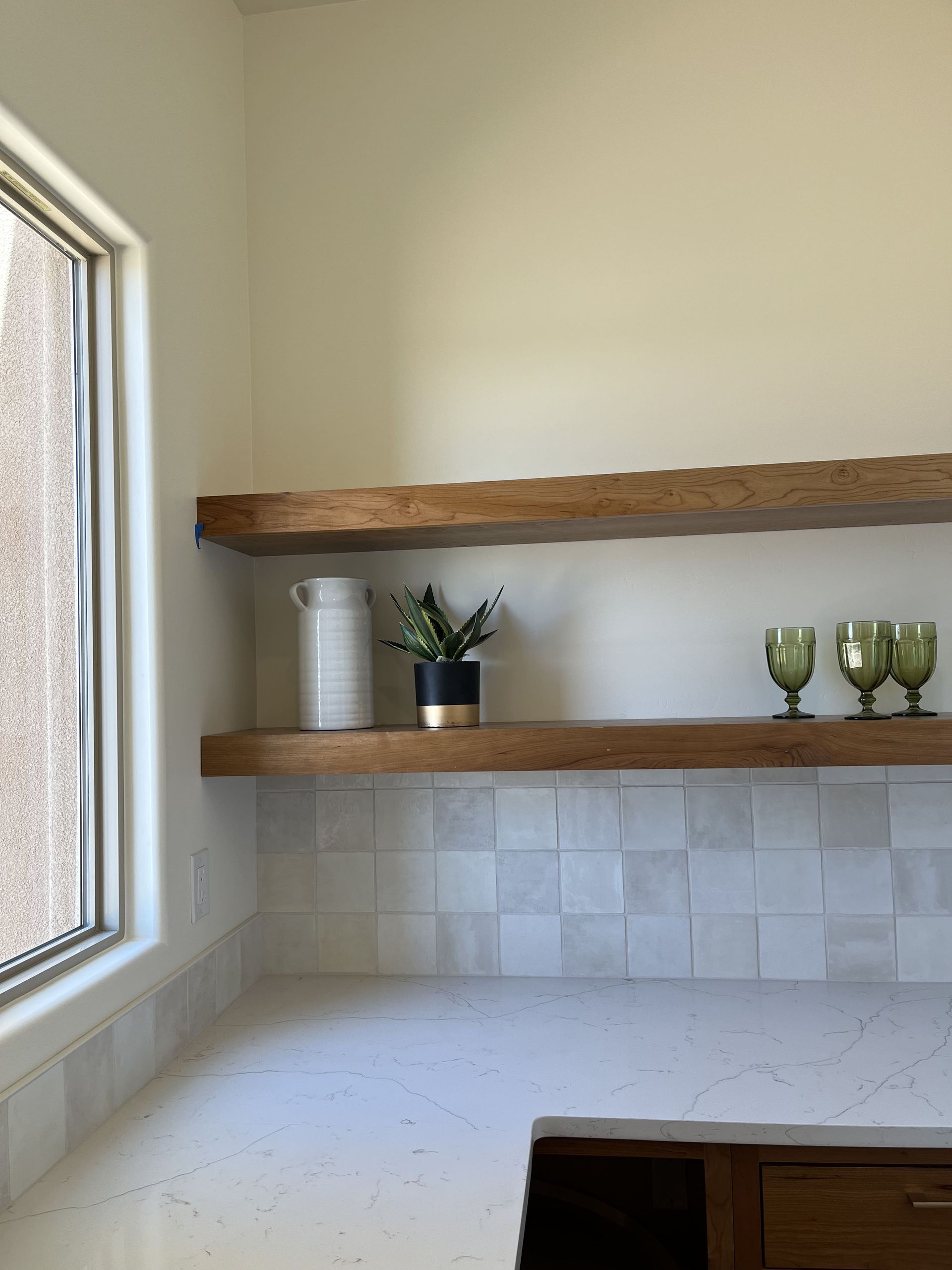 A kitchen with wooden shelves and a window