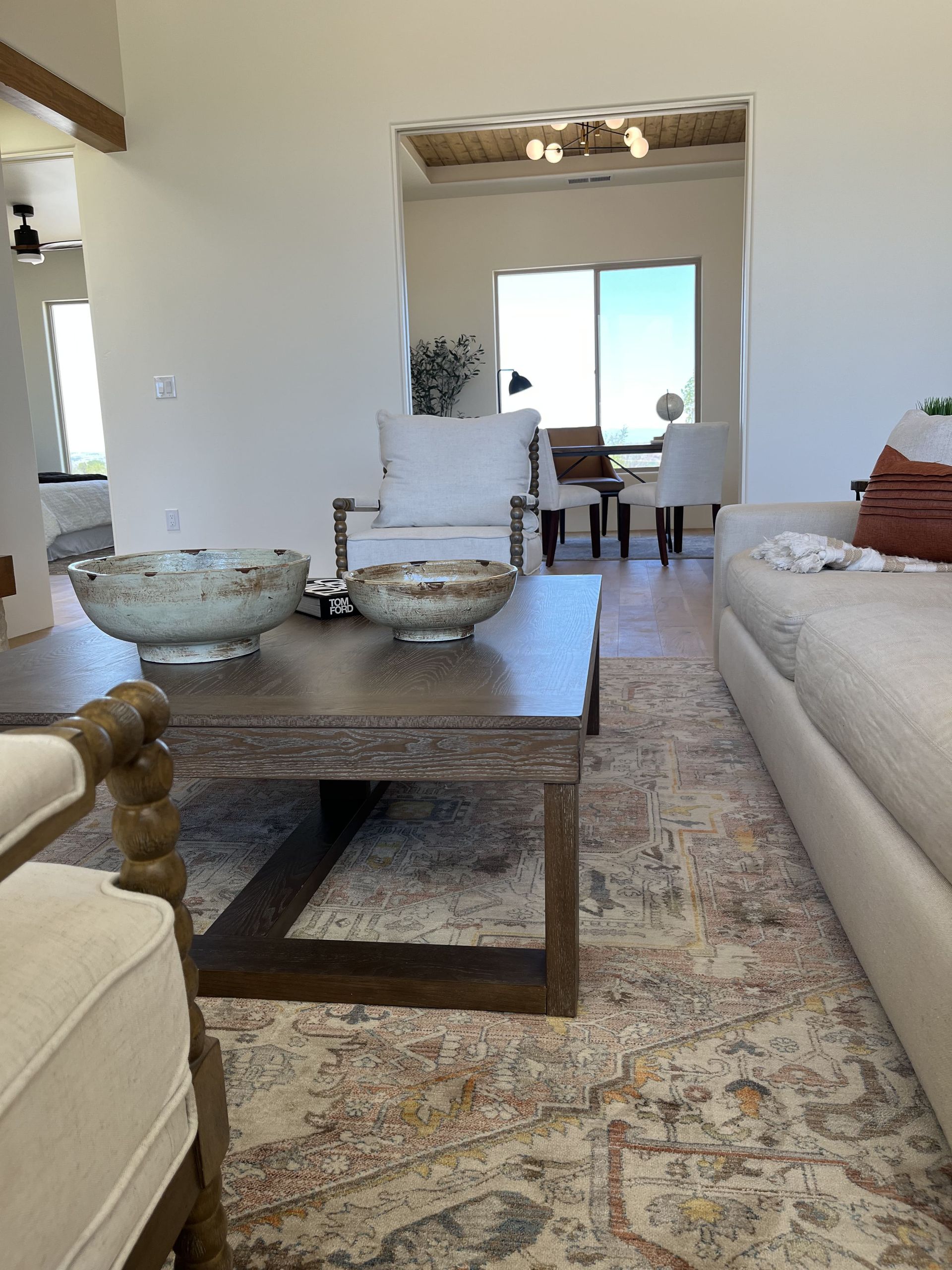 A living room with a coffee table , chairs , and a rug.