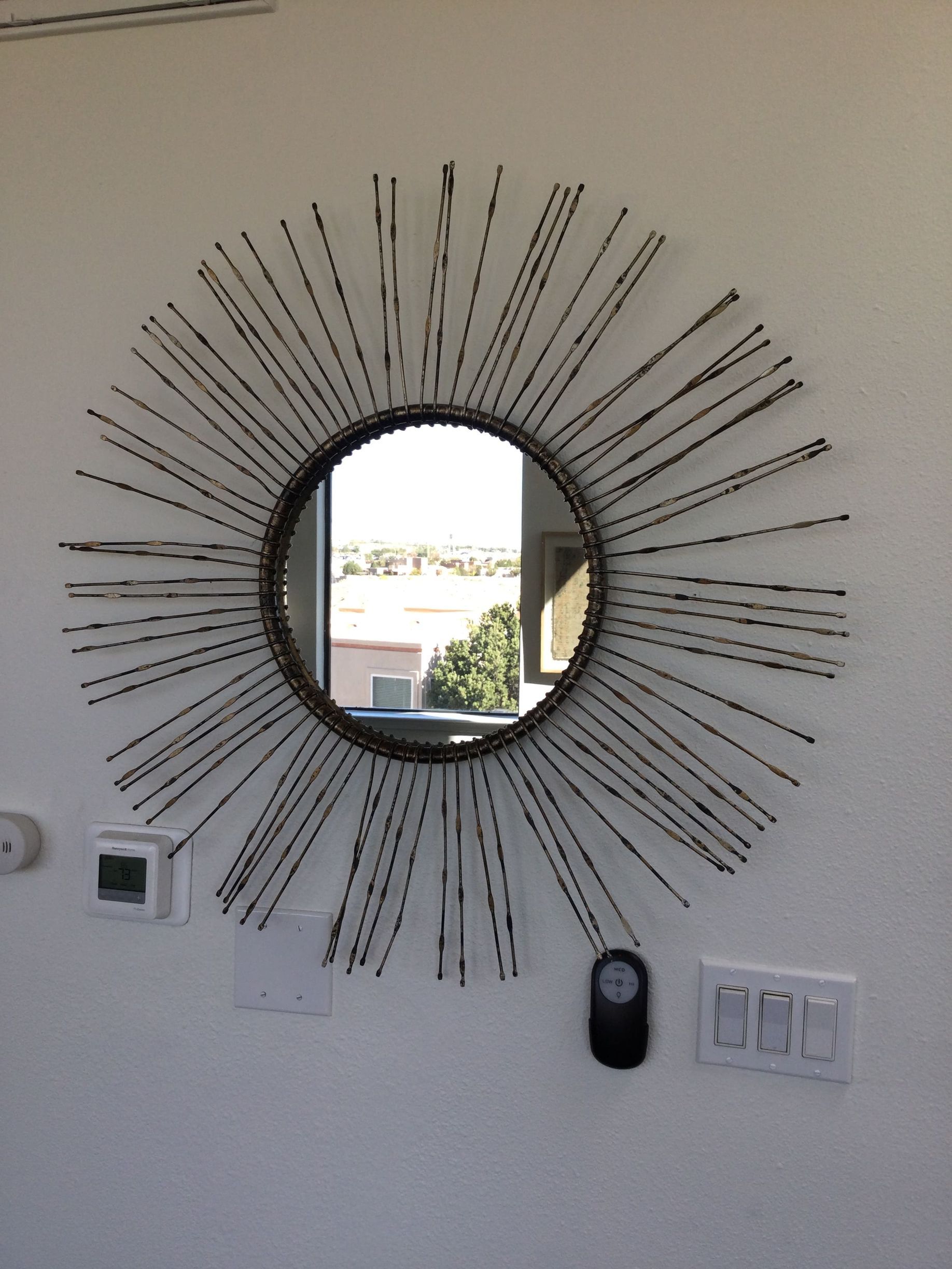 A round mirror with a sunburst design on it