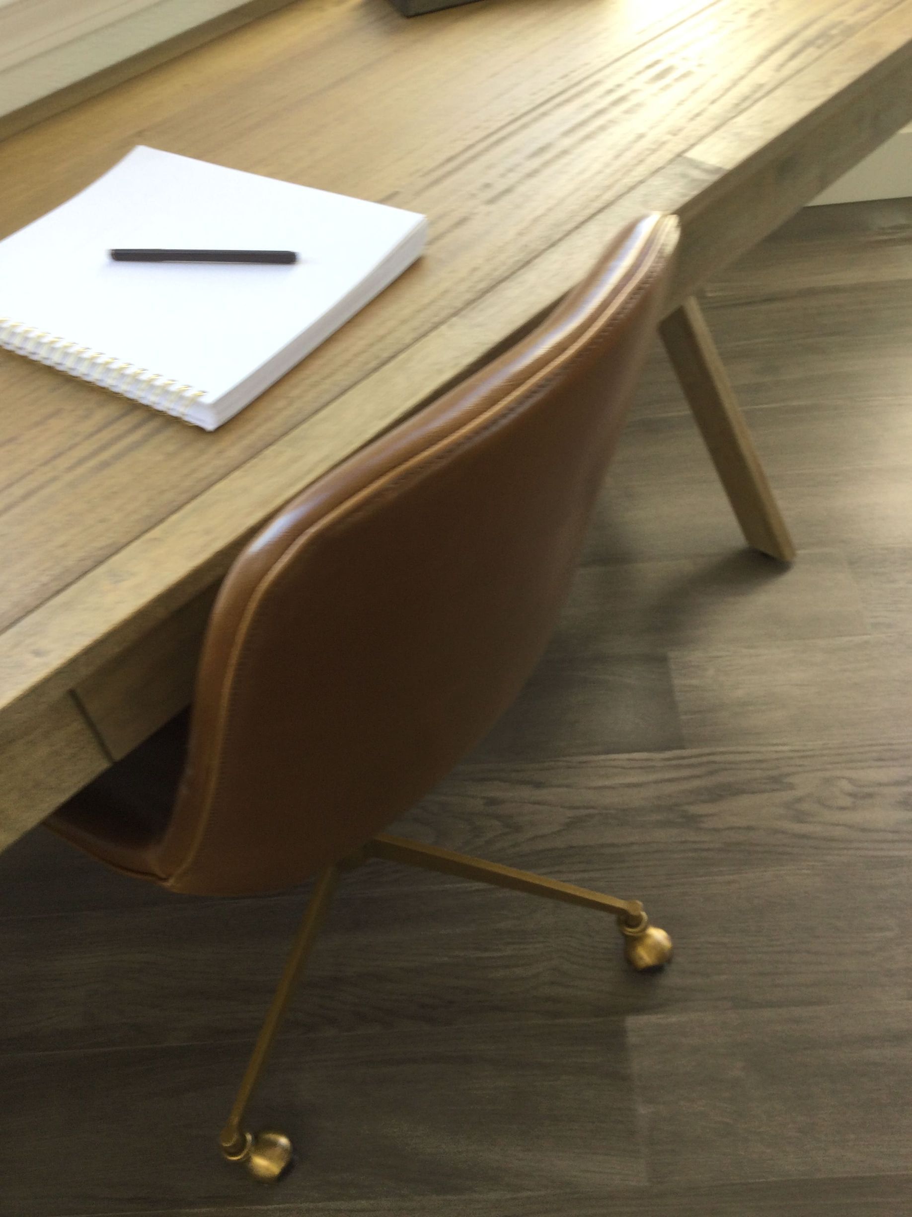 A desk with a chair and a notebook on it