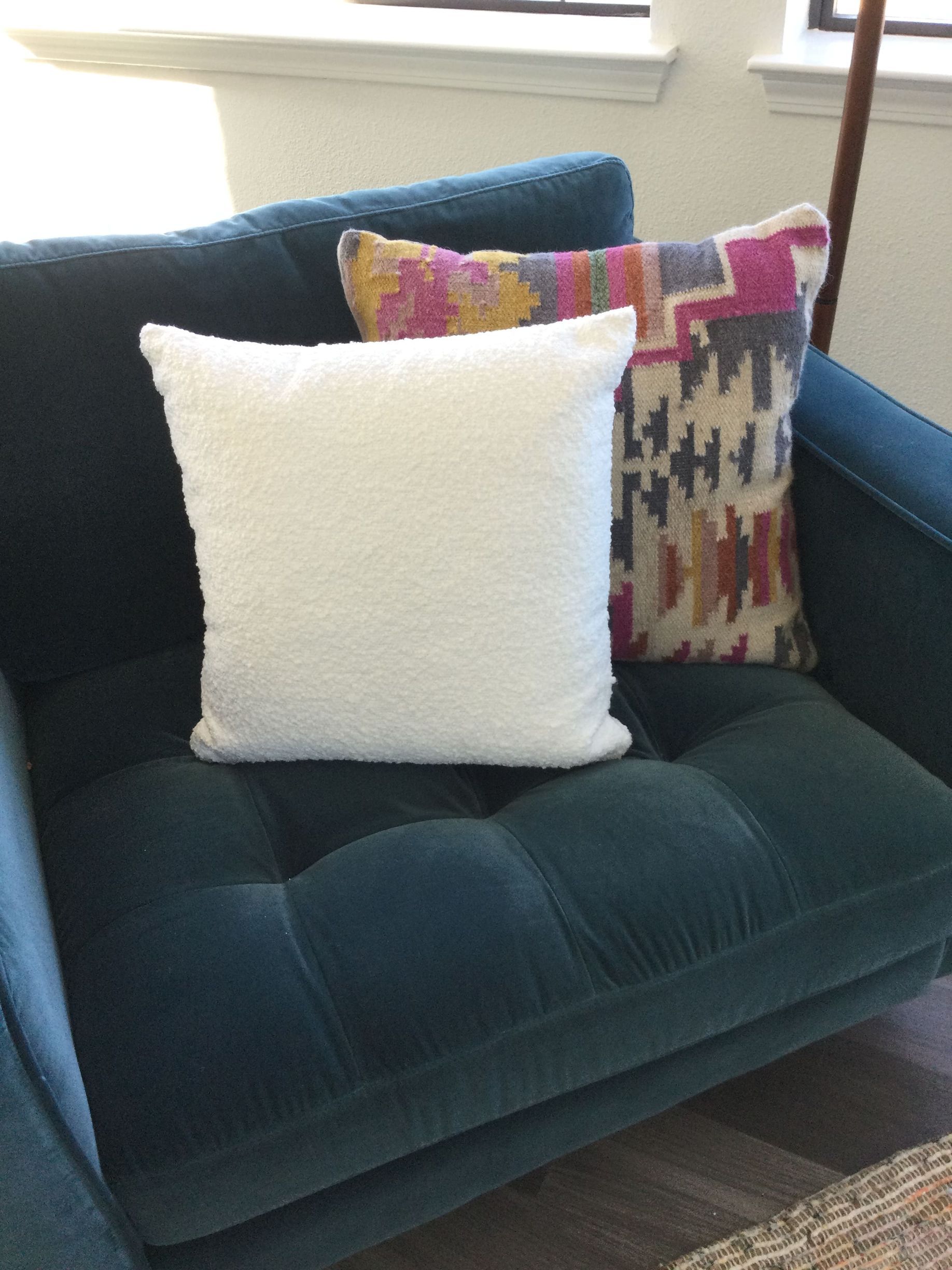 A blue couch with two pillows on it