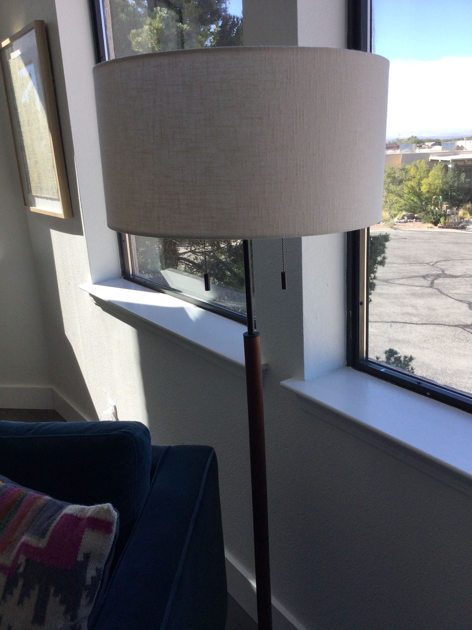 A lamp is sitting in front of a window in a living room