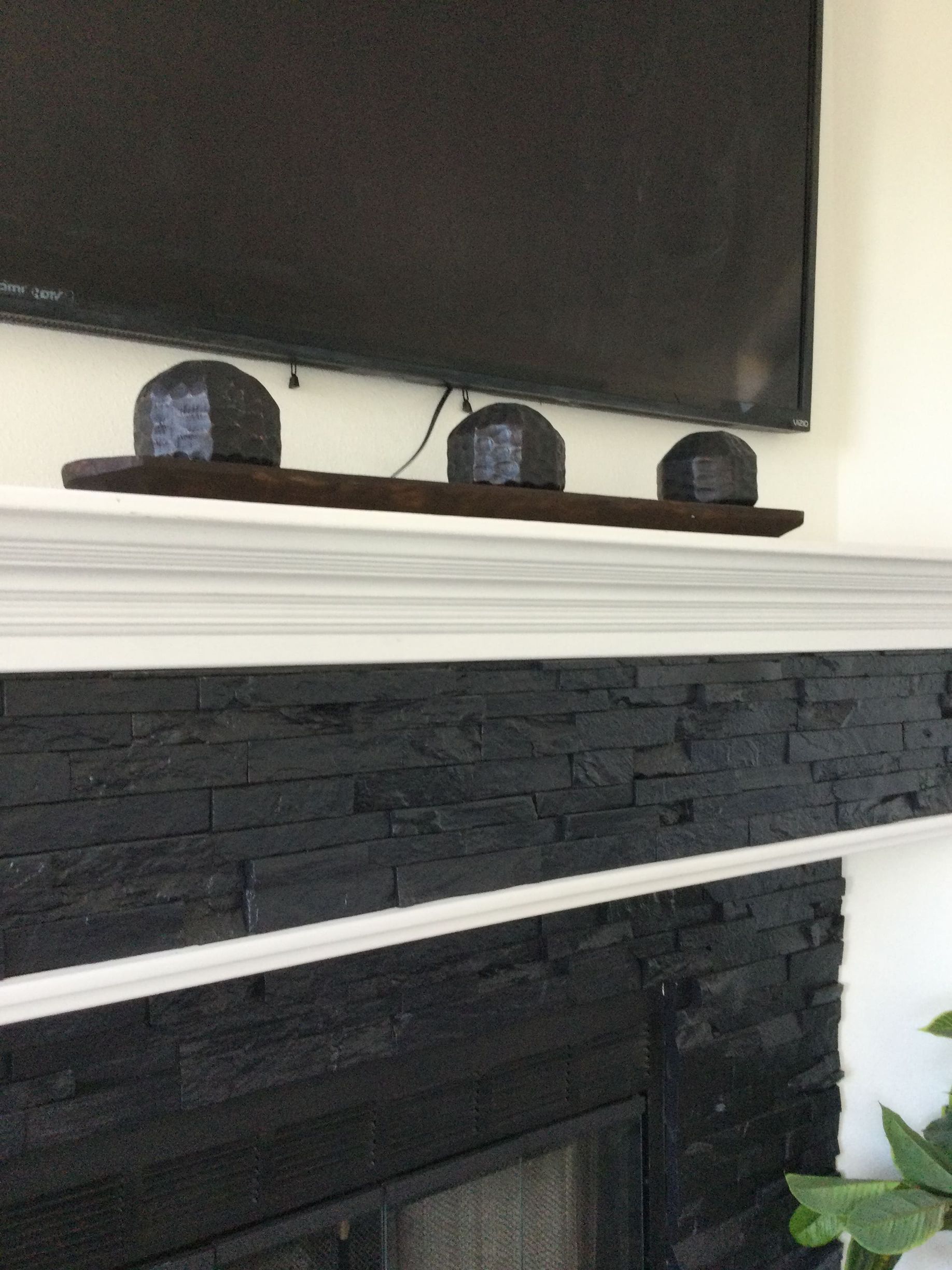 A fireplace with a flat screen tv on top of it.