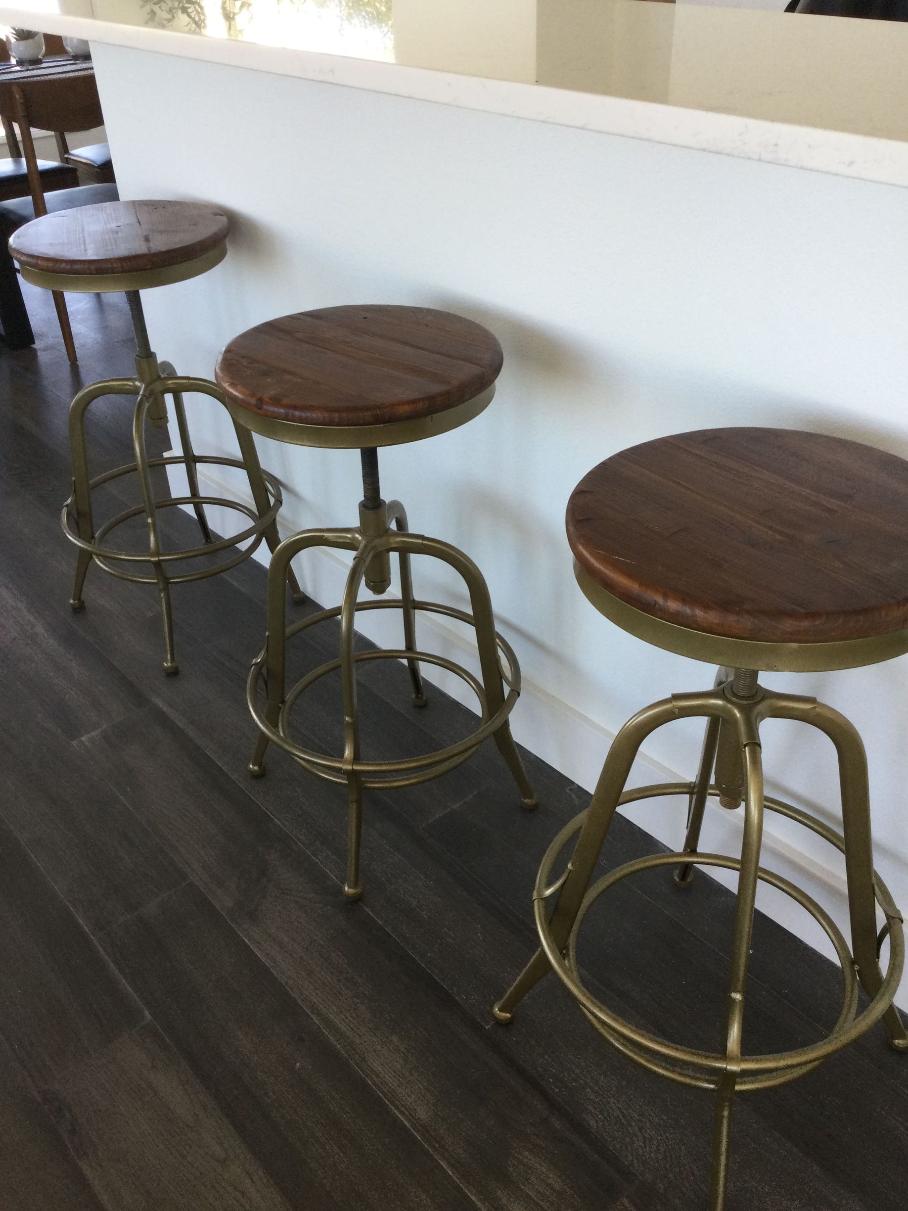 Three bar stools are lined up next to each other