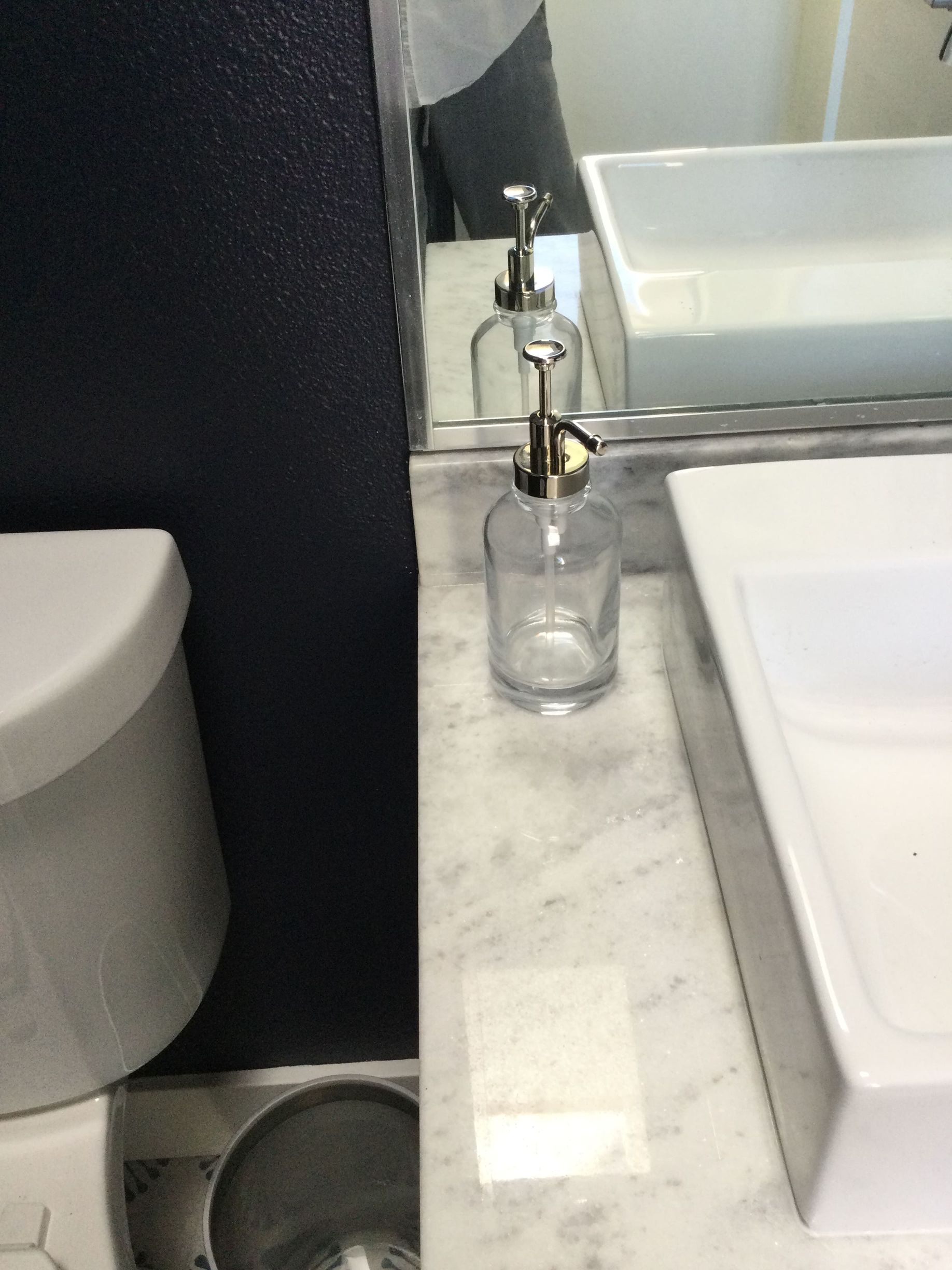 A bathroom with a sink , toilet and mirror