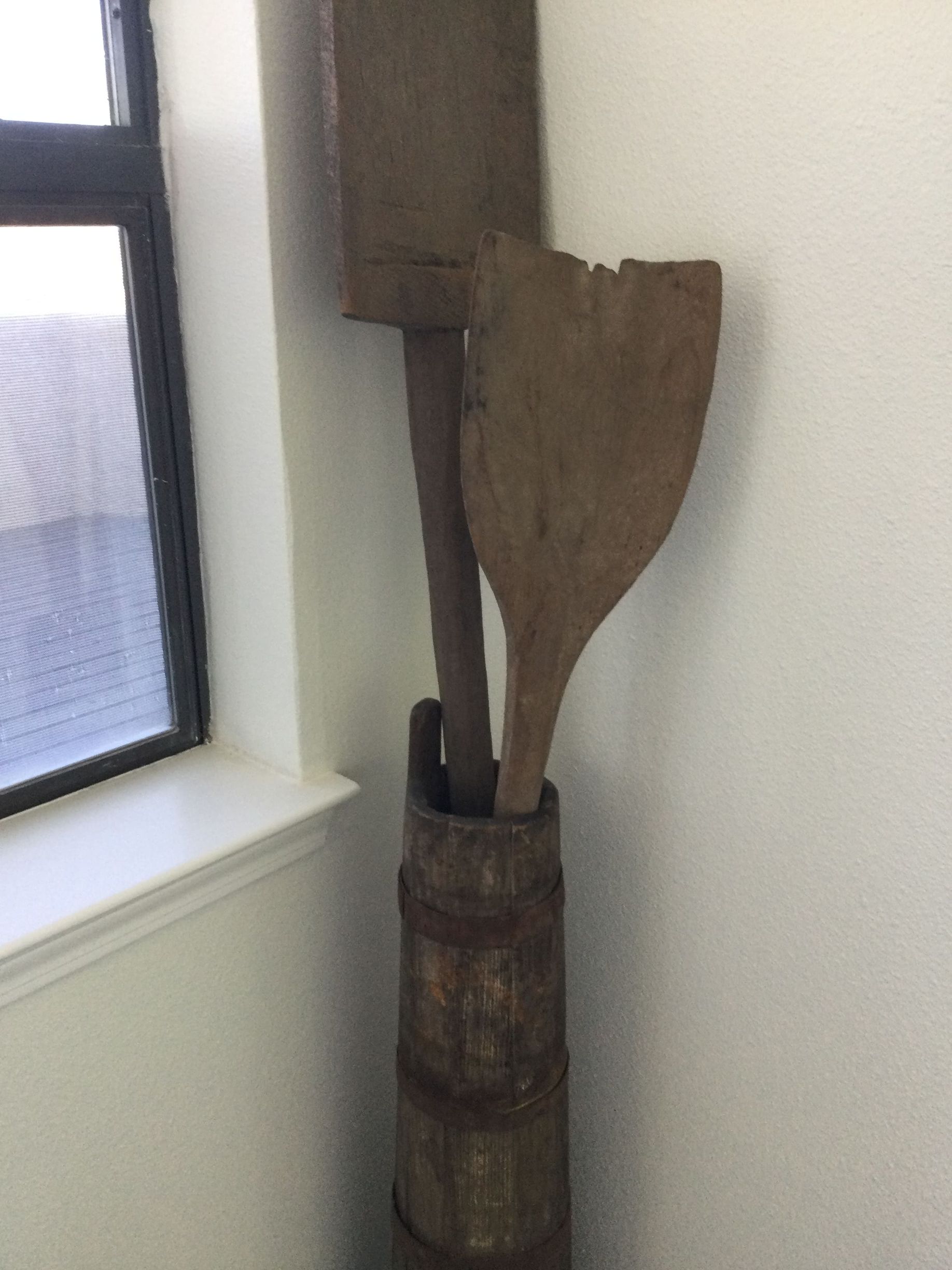 A wooden bucket with a wooden spoon in it