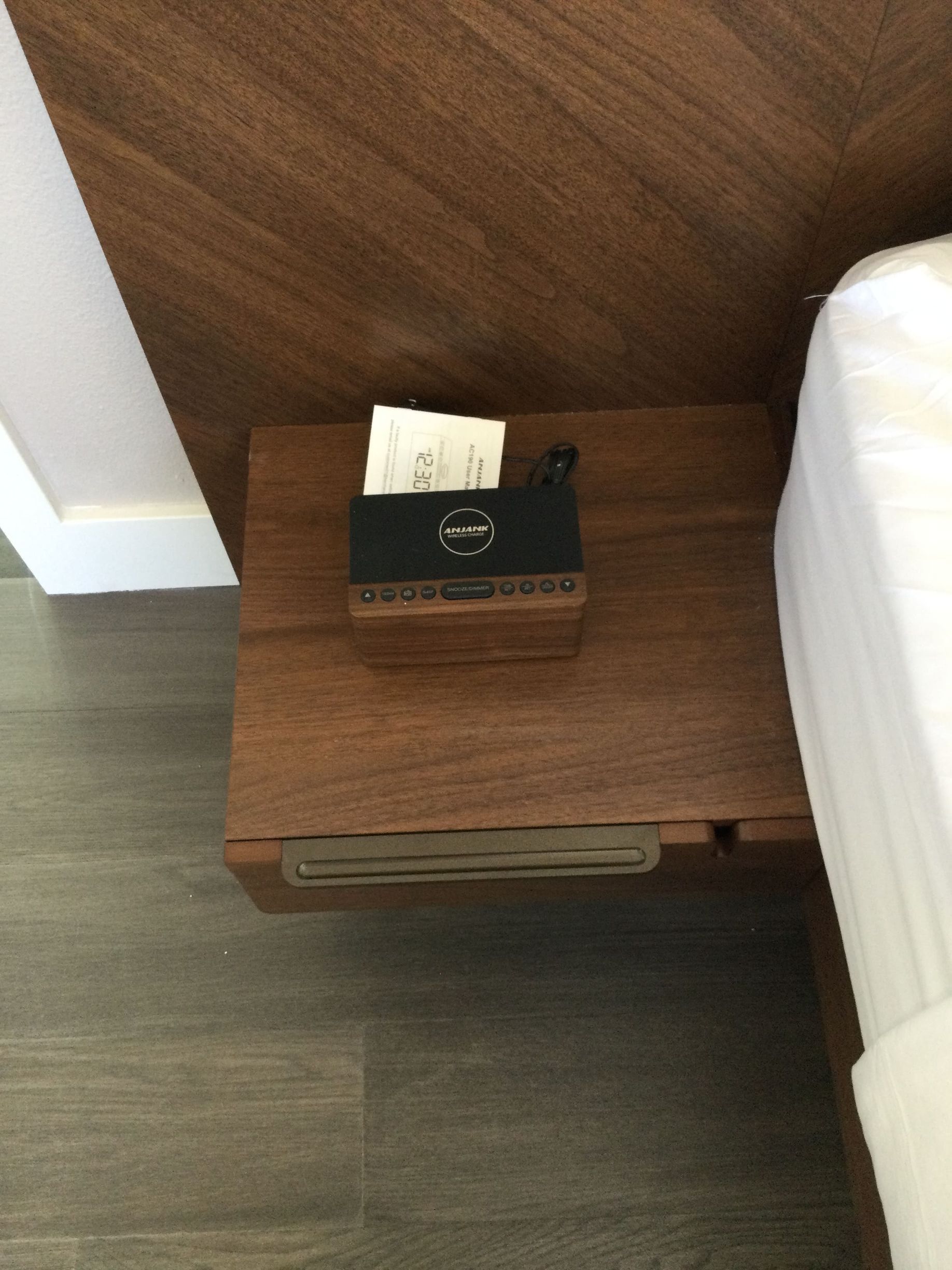 A wooden nightstand with a box of tissues on it